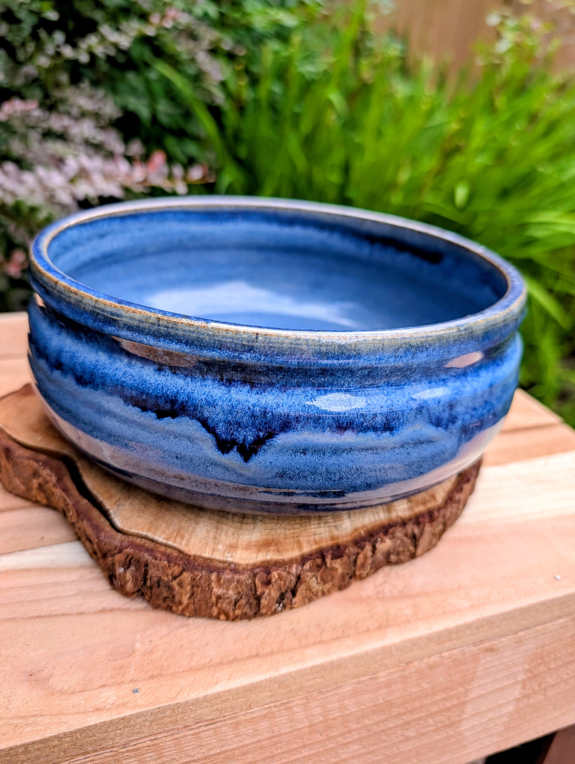 A beautifully hand-thrown studio pottery bowl dated 1990, featuring a rich satin cobalt blue glaze with a subtle spiral movement across the interior. Signed by the artist (maker currently unconfirmed), this functional stoneware piece blends everyday usefulness with timeless handcrafted artistry.