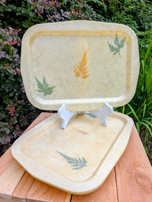 Bring the beauty of nature indoors with this vintage spun fiberglass serving tray featuring real preserved botanical specimens suspended in translucent resin. Lightweight yet durable, each tray showcases the timeless craftsmanship and organic style that defined mid-century American housewares.