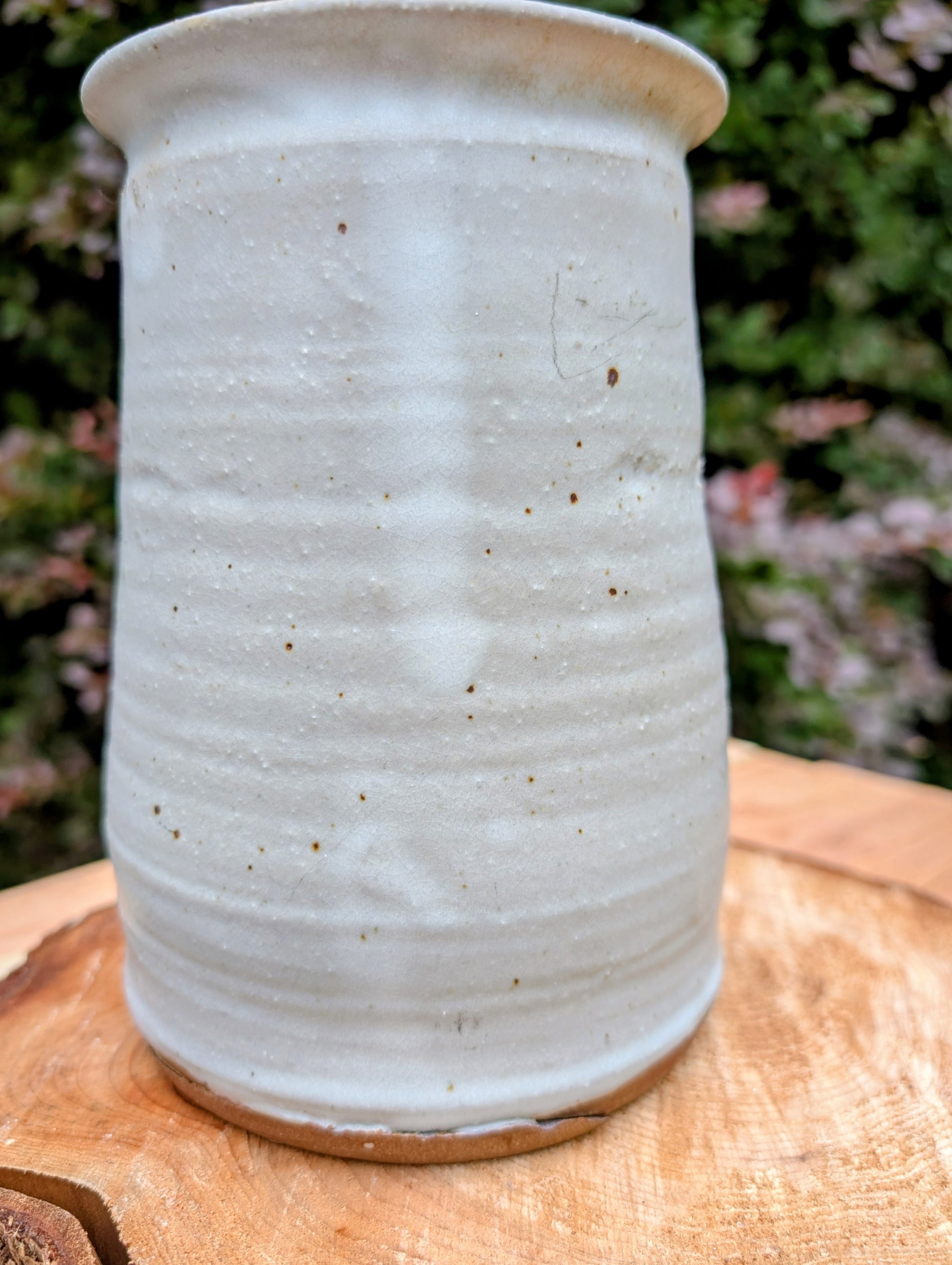 Bring warmth and handcrafted character to your kitchen with this wheel-thrown stoneware canister. Finished in a soft creamy-white glaze with subtle iron speckling, this timeless storage vessel blends rustic craftsmanship with modern organic design.