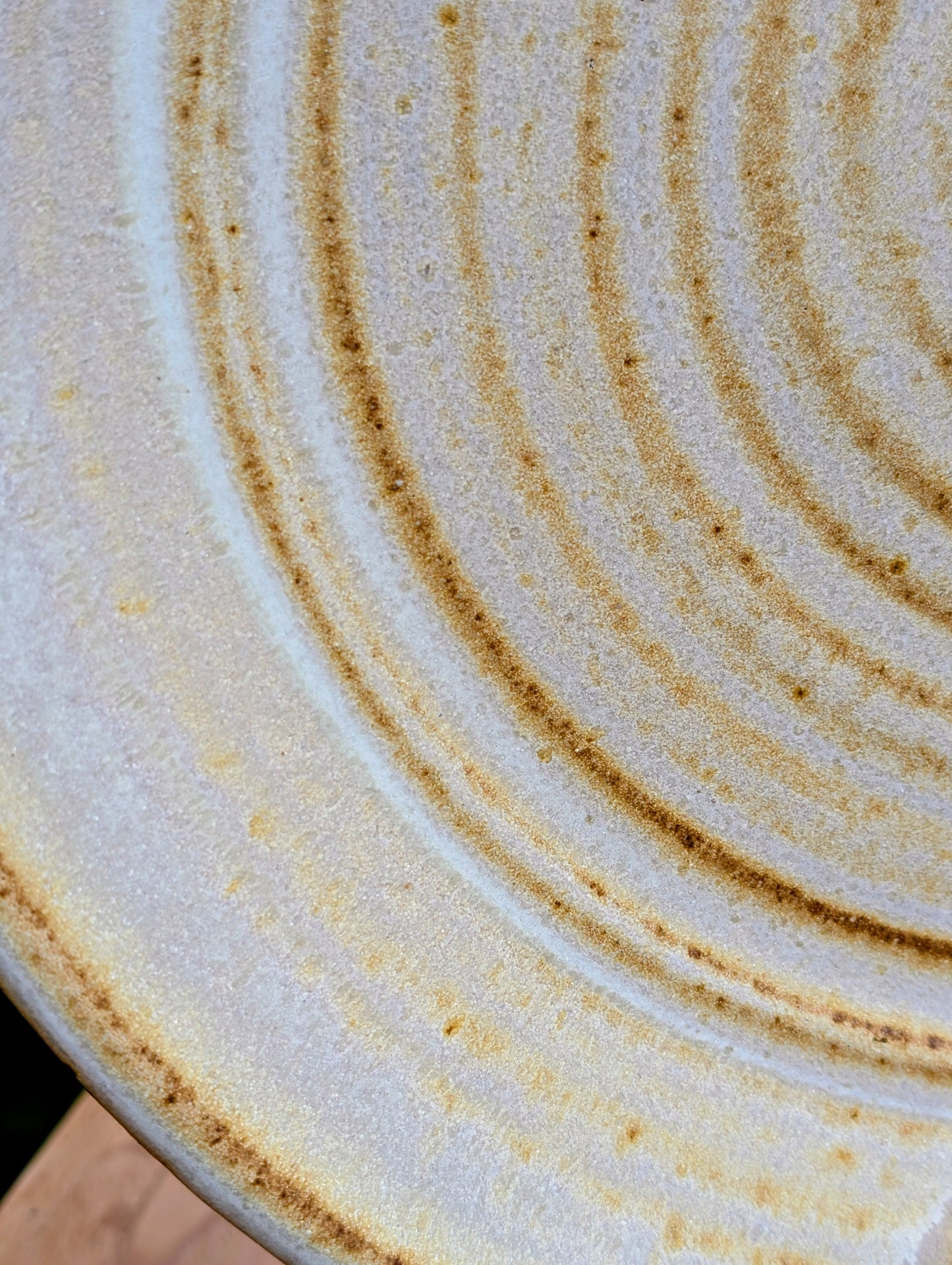 A striking hand-thrown studio pottery platter featuring an expressive cream, maroon, and olive glaze composition with visible throwing rings and an incised artist signature. Beautiful as both a decorative wall display and a functional serving piece, it embodies the warmth and craftsmanship of contemporary American studio ceramics.