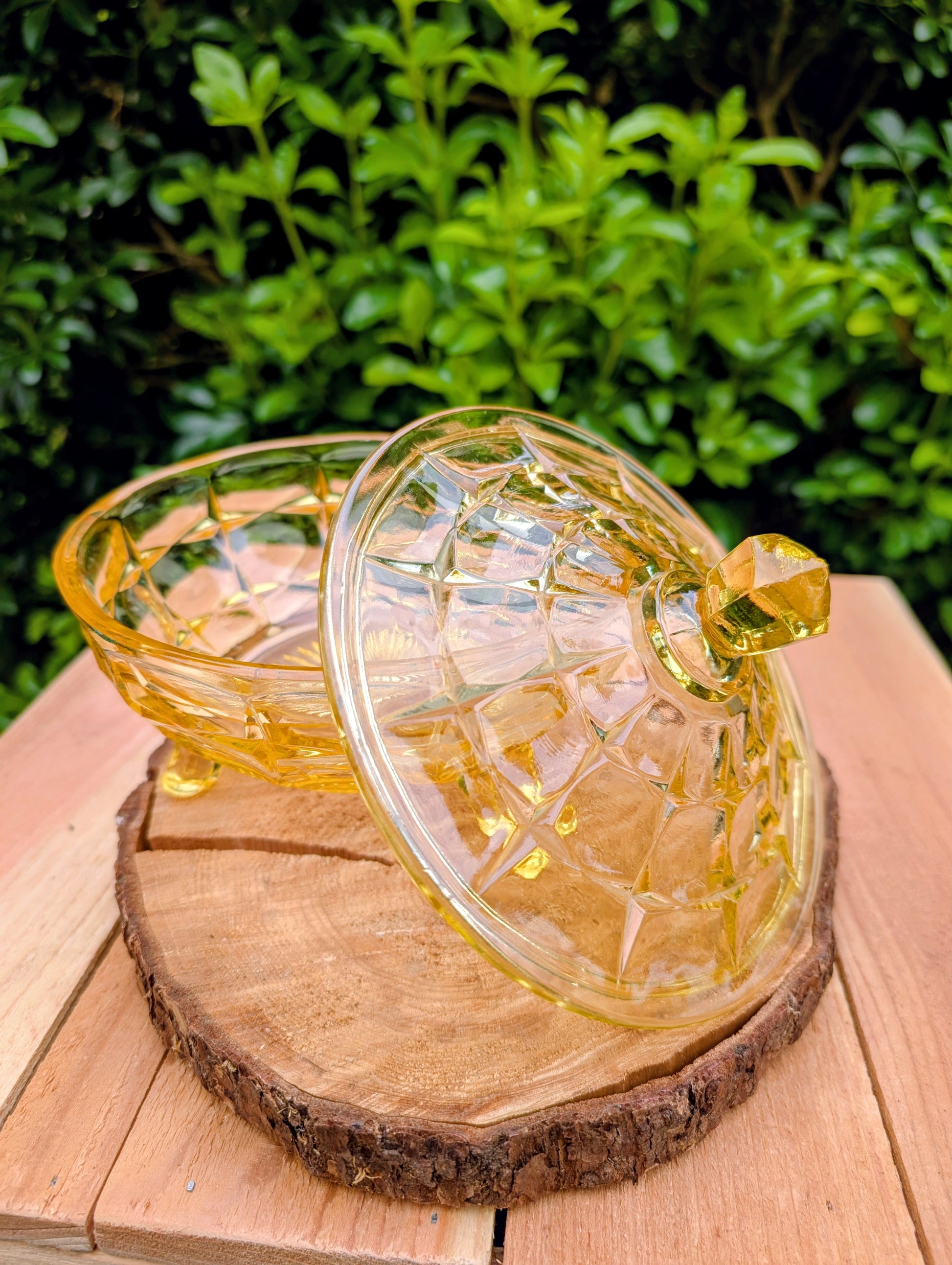 Bring warm vintage charm to your home with this beautiful Tiara Exclusives Constellation covered candy dish in the sought-after Yellow Mist color. Produced by Indiana Glass during the 1970s, its geometric star pattern and golden glow make it a timeless piece for entertaining or display.