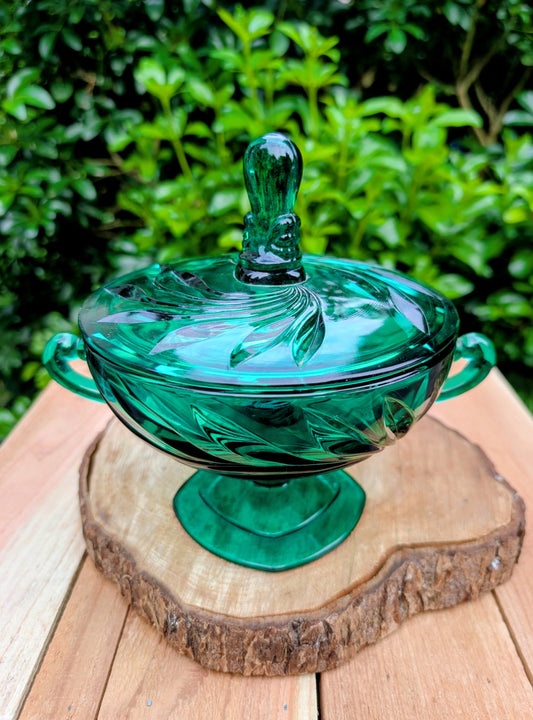 Bring timeless Mid-Century charm to your home with this vintage Indiana Glass Willow covered pedestal candy dish in rich emerald green. Its sculptural leaf motif, elegant pedestal base, and original lid make it a beautiful display piece for entertaining or seasonal décor.