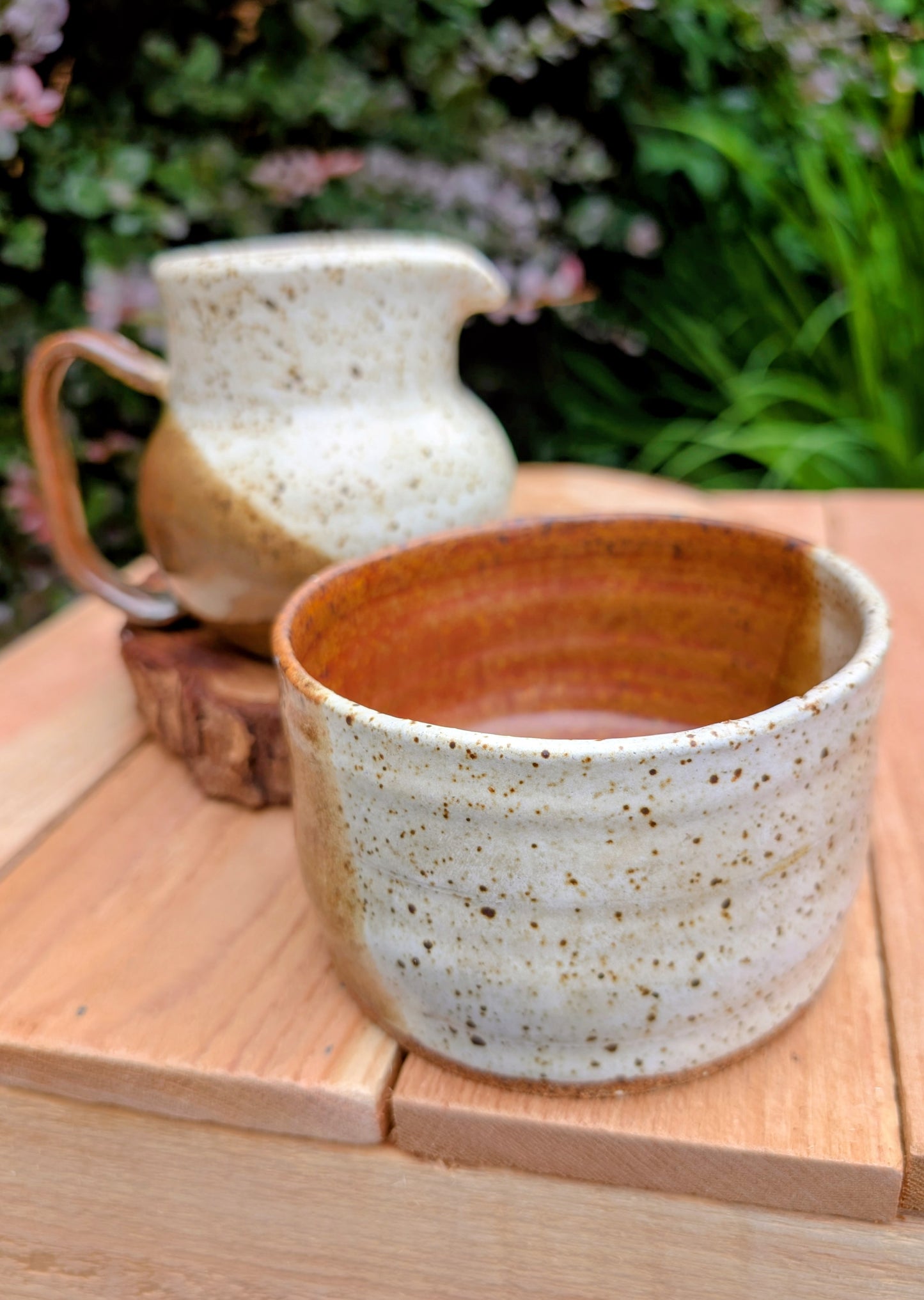 Bring handcrafted warmth to your table with this signed studio pottery creamer and sugar bowl set. Finished in a beautiful speckled cream glaze with flowing olive-brown accents, this artisan stoneware pair blends rustic craftsmanship with timeless everyday function.