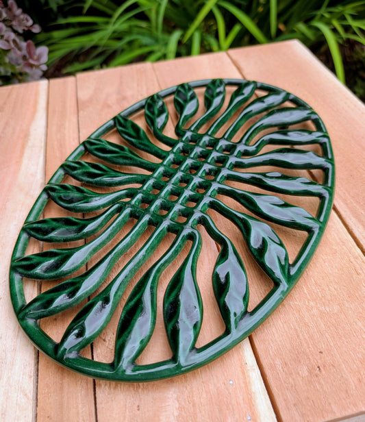 Bring timeless French craftsmanship to your kitchen with this vintage Invicta France cast iron trivet. Finished in a rich hunter green porcelain enamel, its elegant sunburst leaf design serves beautifully as both a functional hot plate and decorative wall accent.