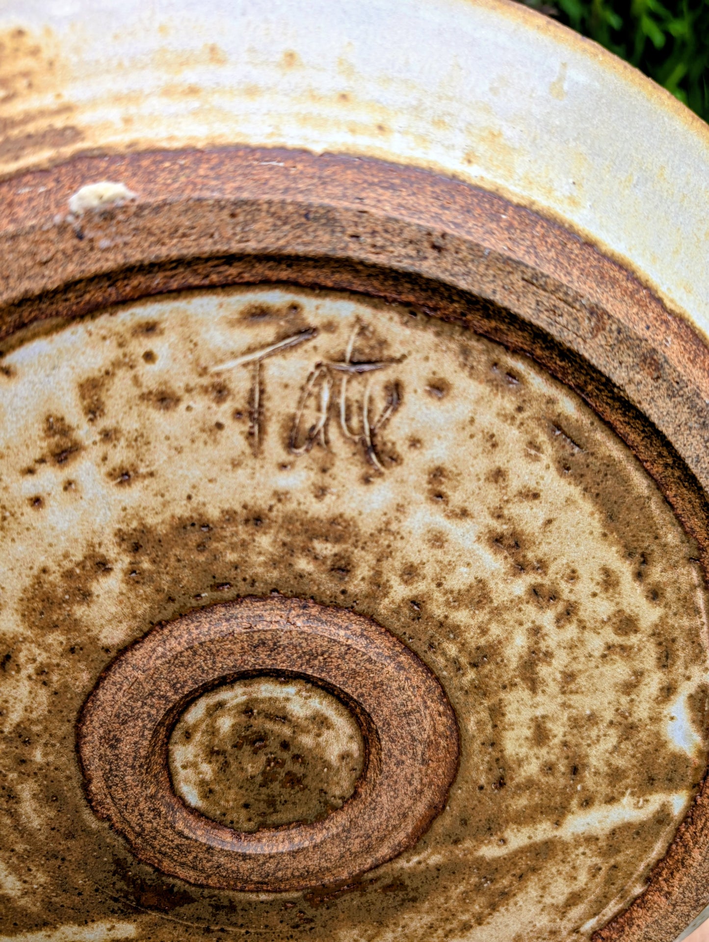 A striking hand-thrown studio pottery platter featuring an expressive cream, maroon, and olive glaze composition with visible throwing rings and an incised artist signature. Beautiful as both a decorative wall display and a functional serving piece, it embodies the warmth and craftsmanship of contemporary American studio ceramics.