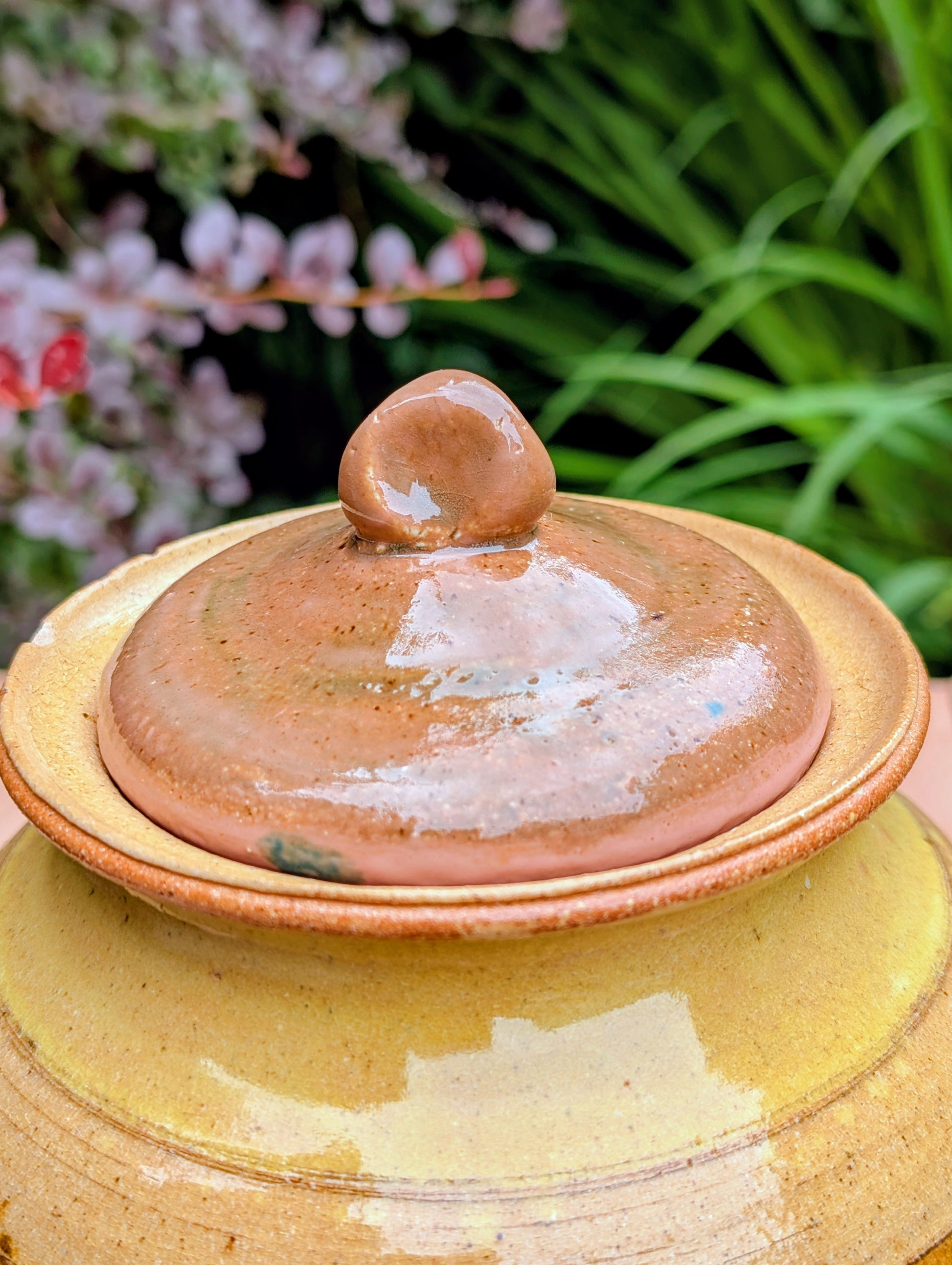 Bring timeless craftsmanship to your kitchen with this handcrafted studio pottery lidded stoneware pot. Finished in warm honey, caramel, olive, and tan glazes, this versatile covered vessel is equally beautiful as functional serveware or rustic farmhouse décor.