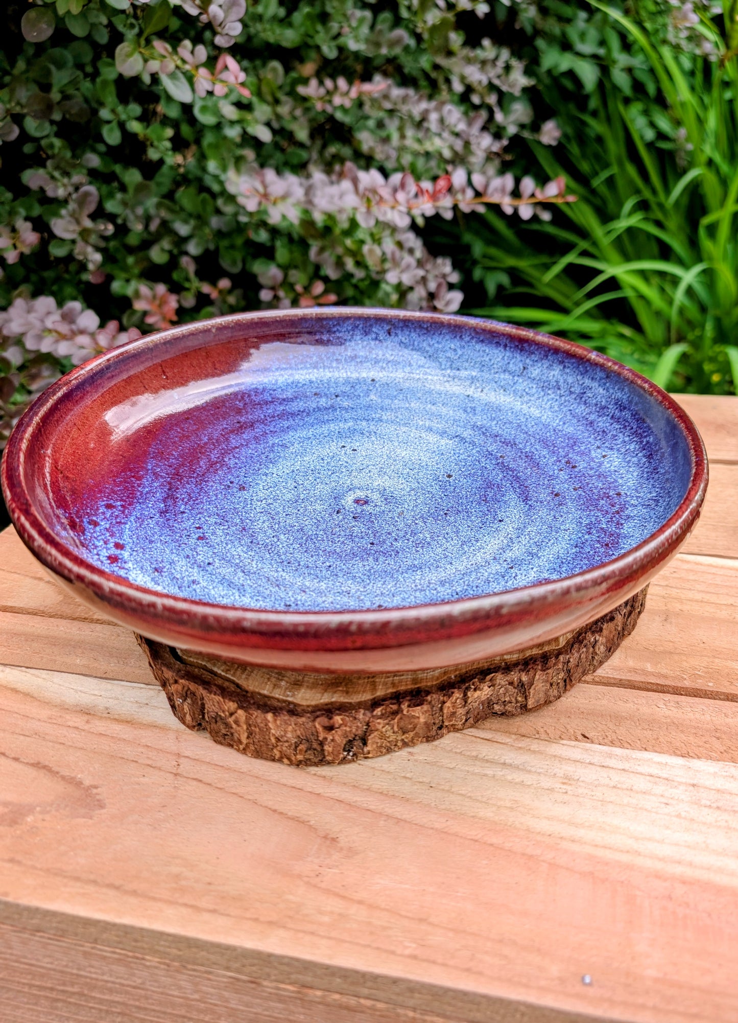 A beautifully hand-thrown studio pottery serving bowl signed and dated 1991, featuring a richly layered cobalt blue interior and deep oxblood exterior glaze. Whether used for serving or displayed as functional art, this handcrafted stoneware piece showcases the timeless beauty of American studio ceramics.