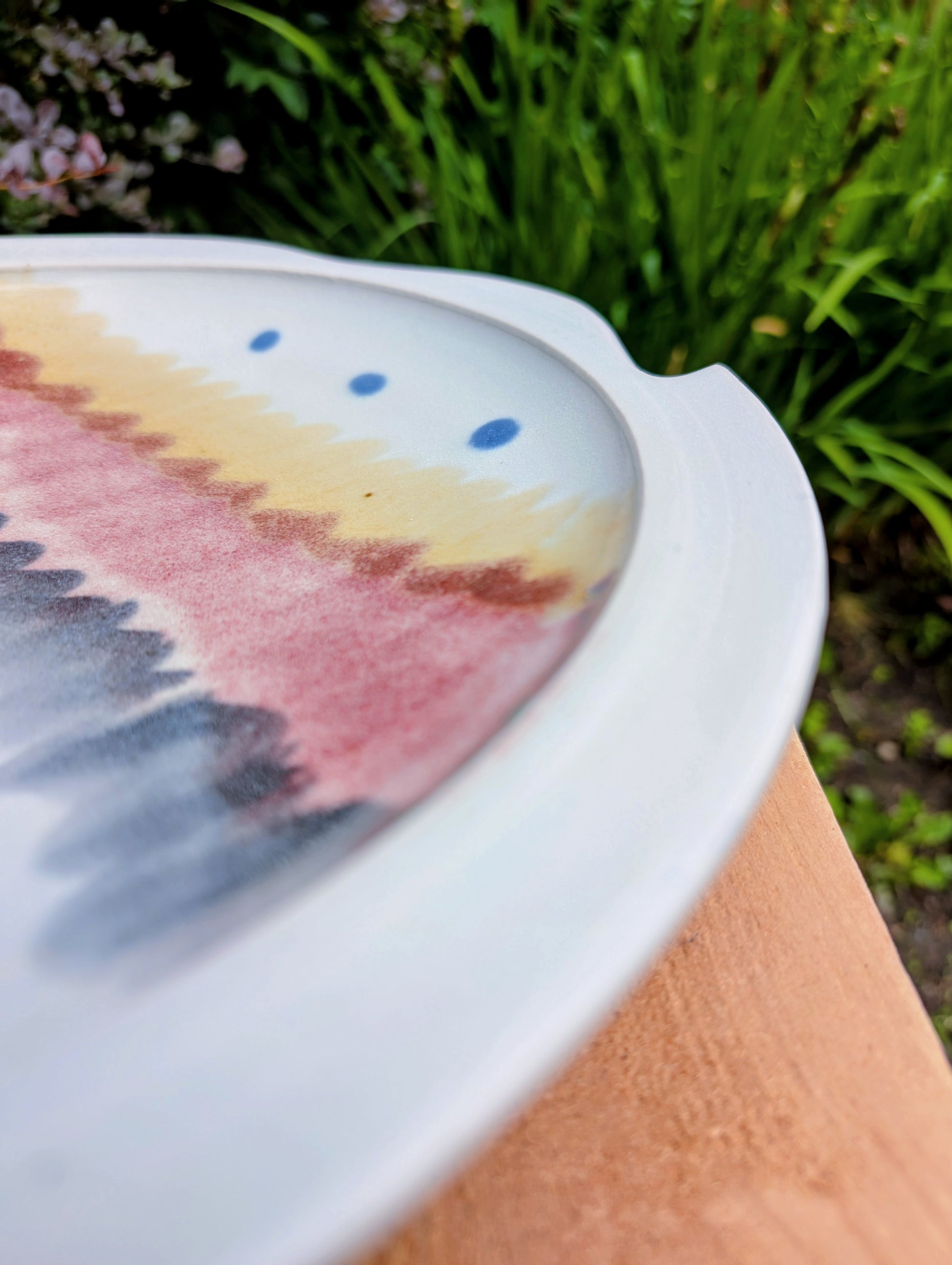 A beautifully handcrafted 14-inch studio pottery platter featuring layered abstract decoration in soft blue-gray, dusty pink, cream, and cobalt accents. Equally stunning as a serving piece or decorative display charger, this artisan-made platter brings timeless craftsmanship to modern living.