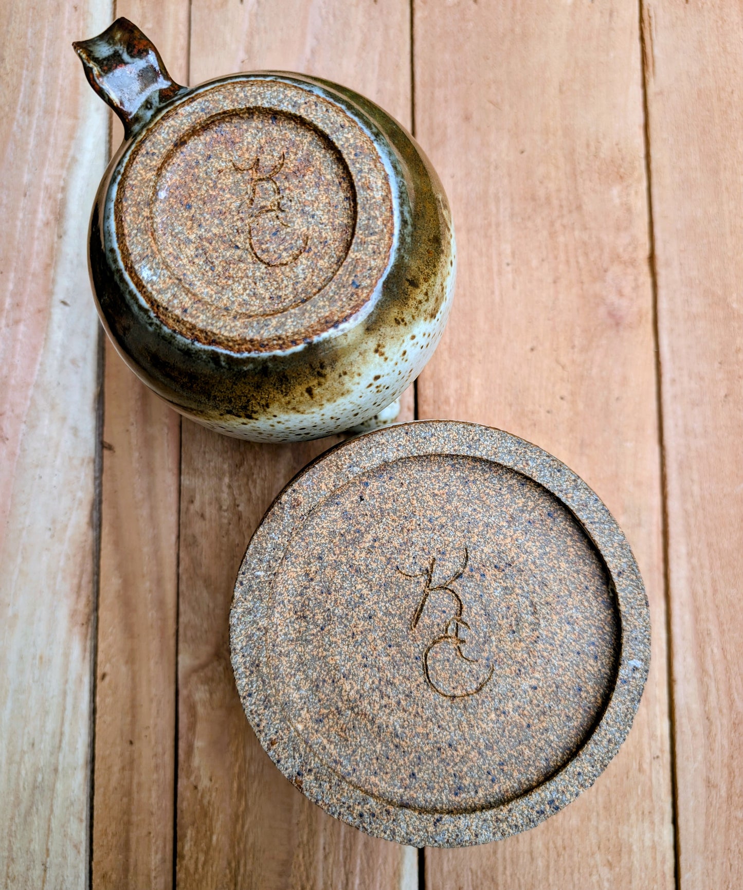 Bring handcrafted warmth to your table with this signed studio pottery creamer and sugar bowl set. Finished in a beautiful speckled cream glaze with flowing olive-brown accents, this artisan stoneware pair blends rustic craftsmanship with timeless everyday function.