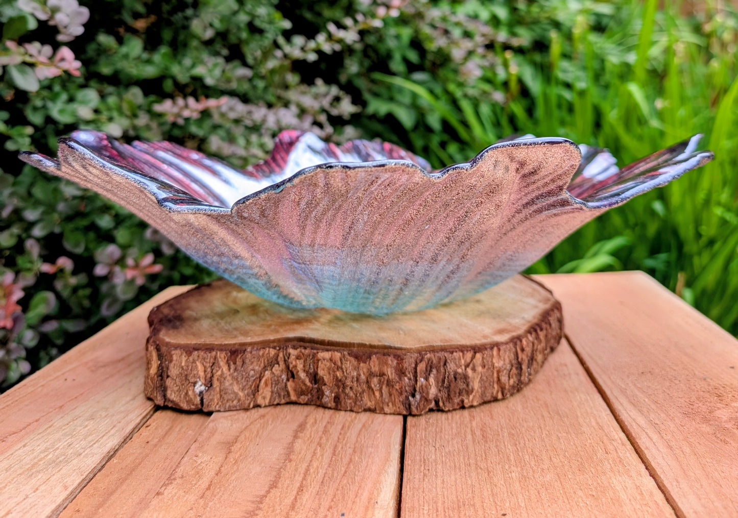 Bring color and artistry to your home or garden with this iridescent art glass floral bowl. Featuring shimmering purple and blue hues, it serves beautifully as either a striking tabletop centerpiece or a decorative bird bath bowl.