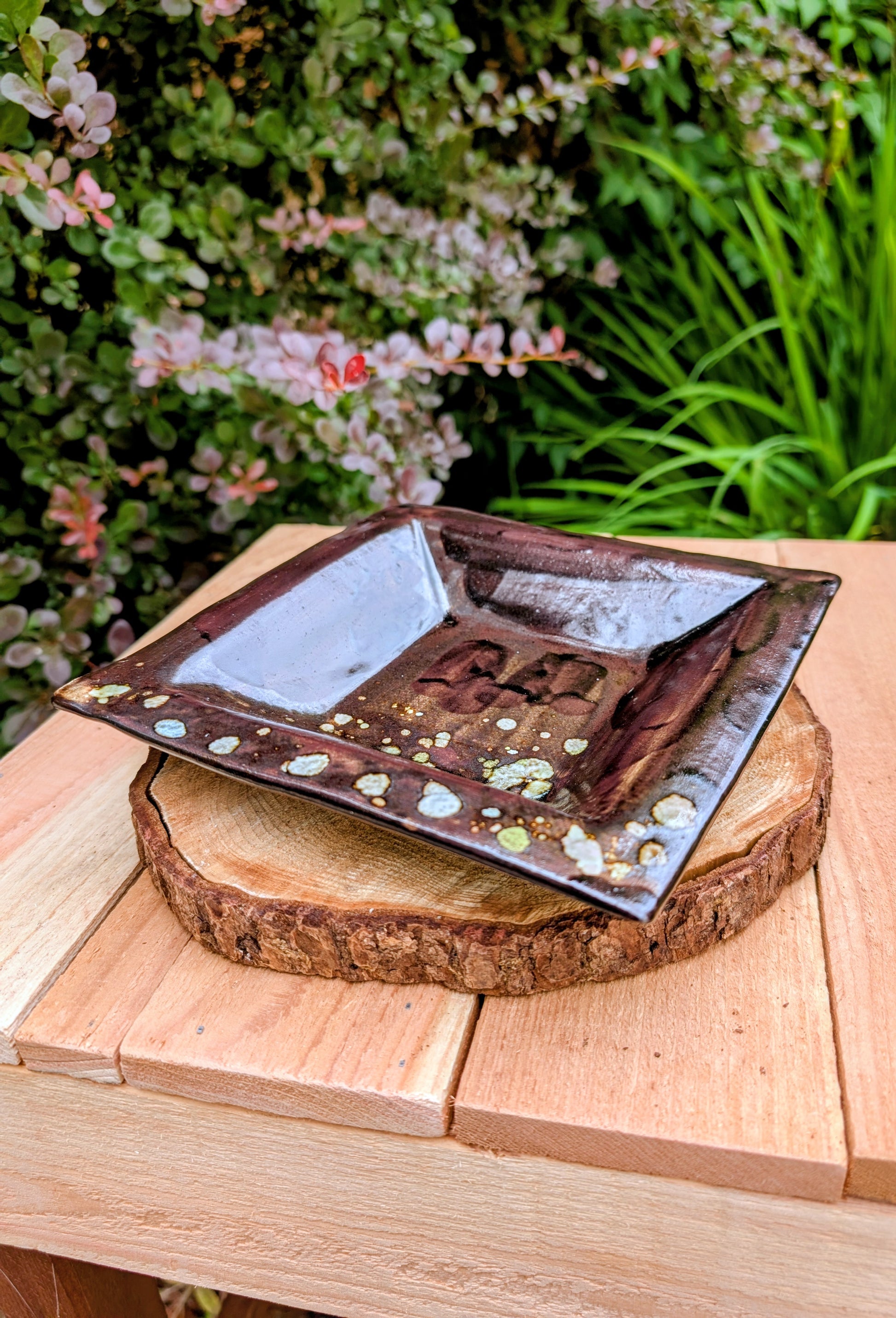 Celebrate the beauty of handcrafted ceramics with this square studio pottery dish featuring layered reactive glazes in rich chocolate brown, gray, olive, cream, and golden crystalline accents. Perfect as a catchall tray, jewelry dish, appetizer plate, or decorative accent, it brings organic warmth to any space.