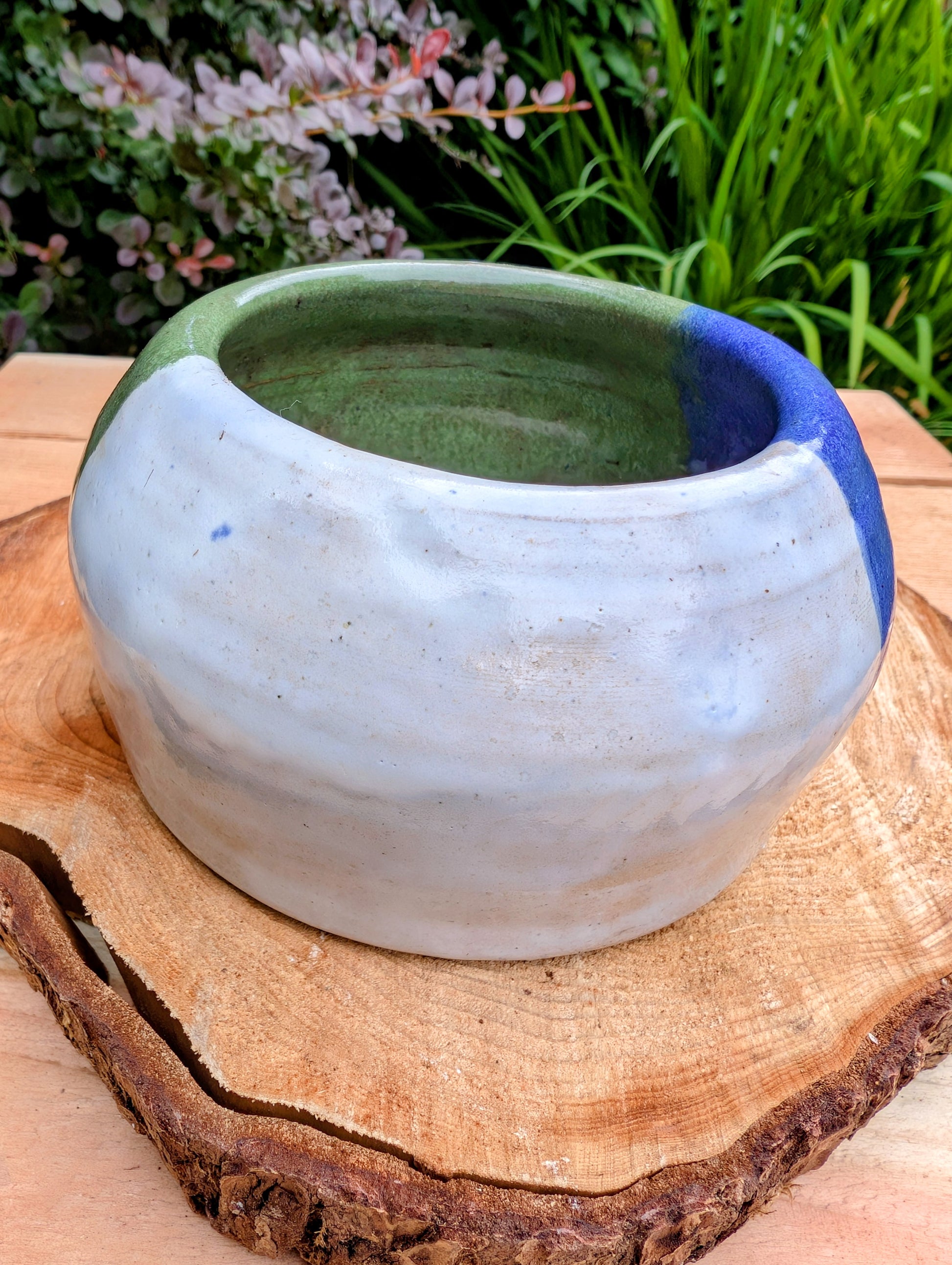 A beautifully hand-thrown studio pottery succulent planter featuring layered blue, moss green, and soft white glazes over high-fired stoneware. Complete with an integrated drainage hole and signed by the artist with the monogram "G.M.," this artisan planter brings handcrafted character to any home or garden.