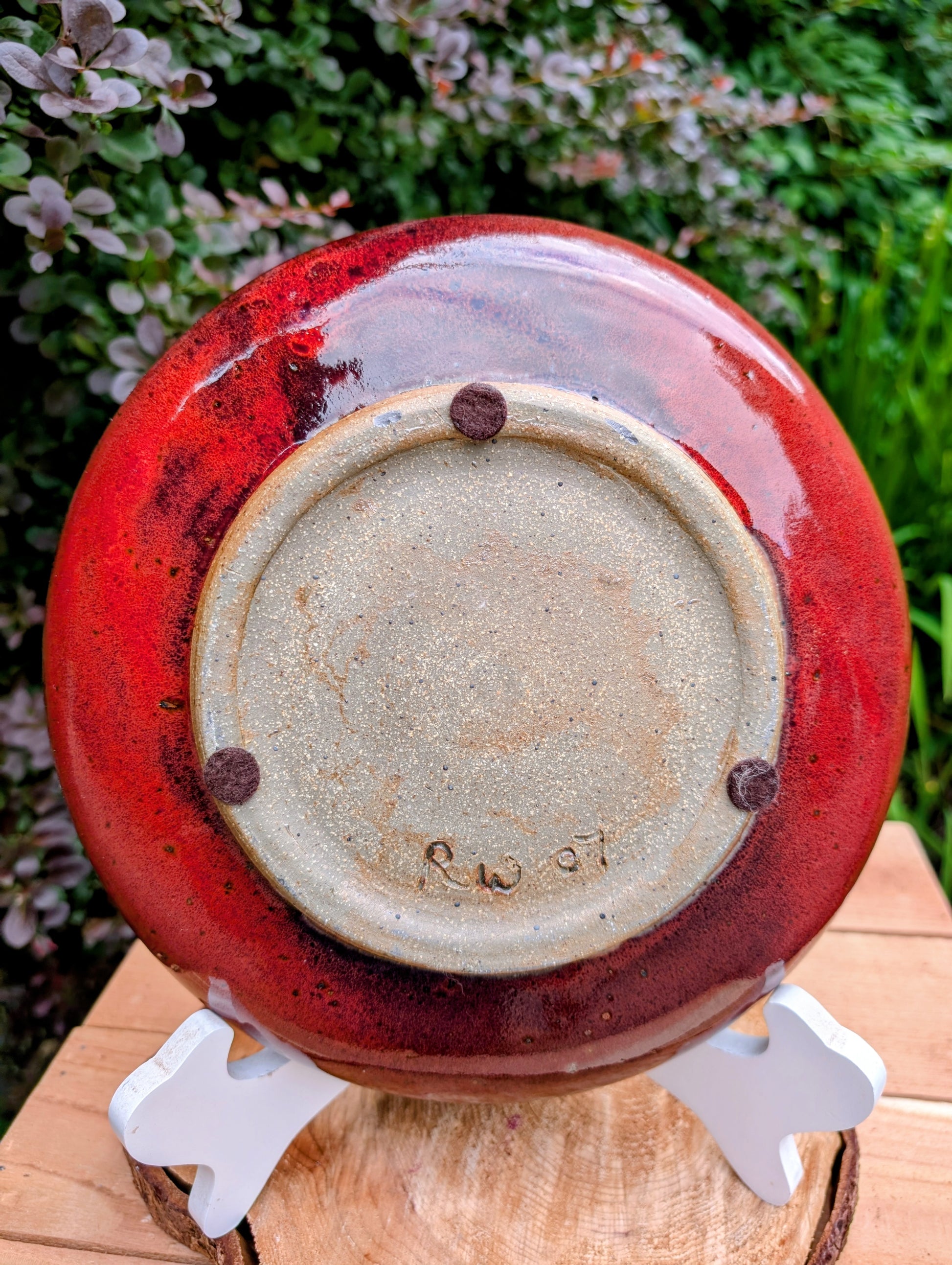 A beautifully hand-thrown studio pottery serving bowl signed and dated 1991, featuring a richly layered cobalt blue interior and deep oxblood exterior glaze. Whether used for serving or displayed as functional art, this handcrafted stoneware piece showcases the timeless beauty of American studio ceramics.
