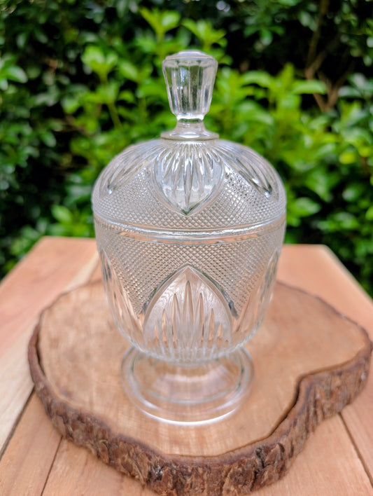 Bring timeless vintage charm to your home with this elegant clear pressed glass covered candy dish featuring a classic diamond-point pattern and pedestal base. Perfect for displaying wrapped candies, jewelry, potpourri, or treasured keepsakes, this versatile piece adds sparkle to any room.