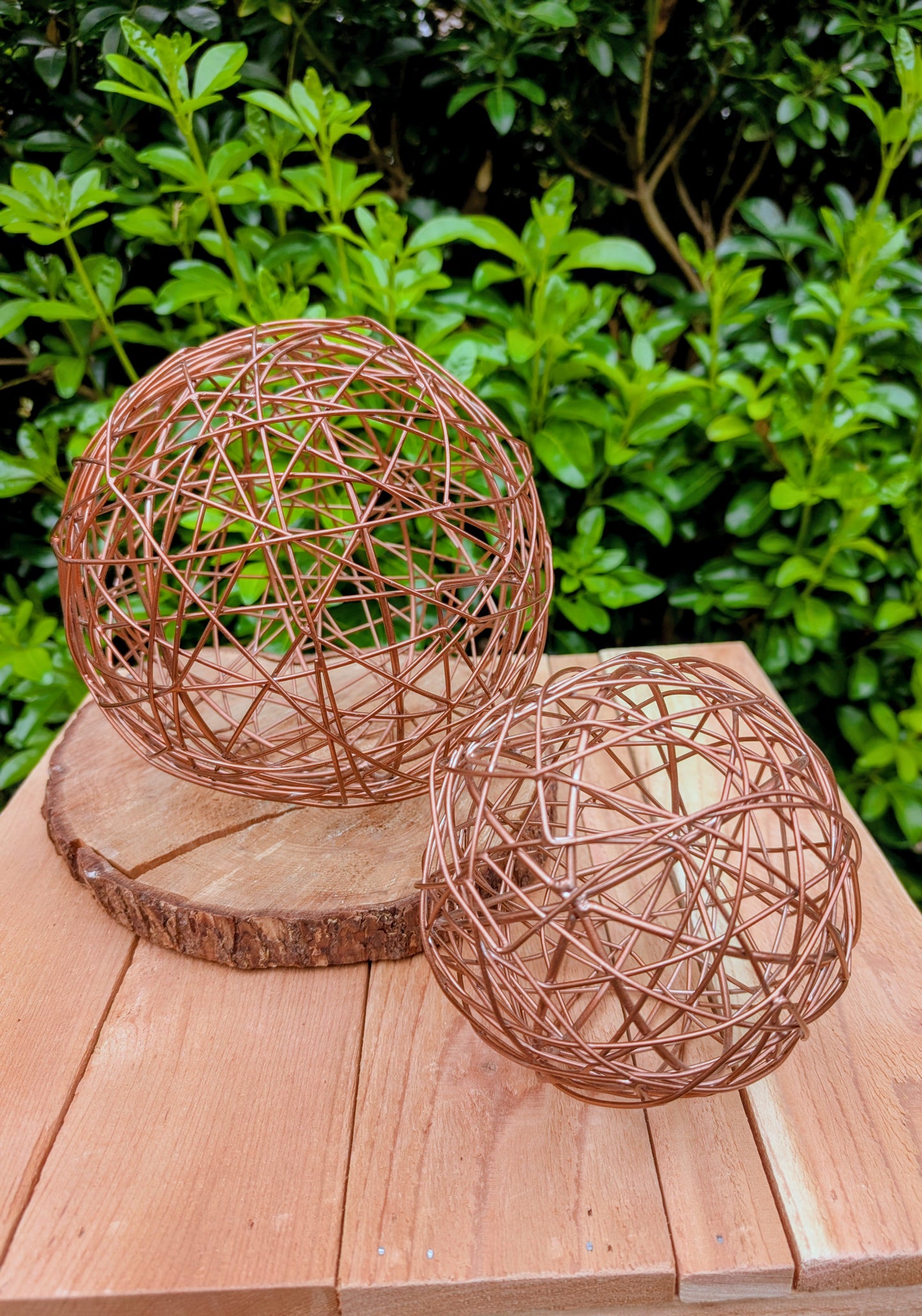 Bring warmth and texture to your home with this coordinated set of two copper-tone woven metal decorative spheres. Their sculptural open-weave design complements modern organic, farmhouse, industrial, and contemporary interiors, making them versatile accents for shelves, coffee tables, decorative bowls, and centerpieces.