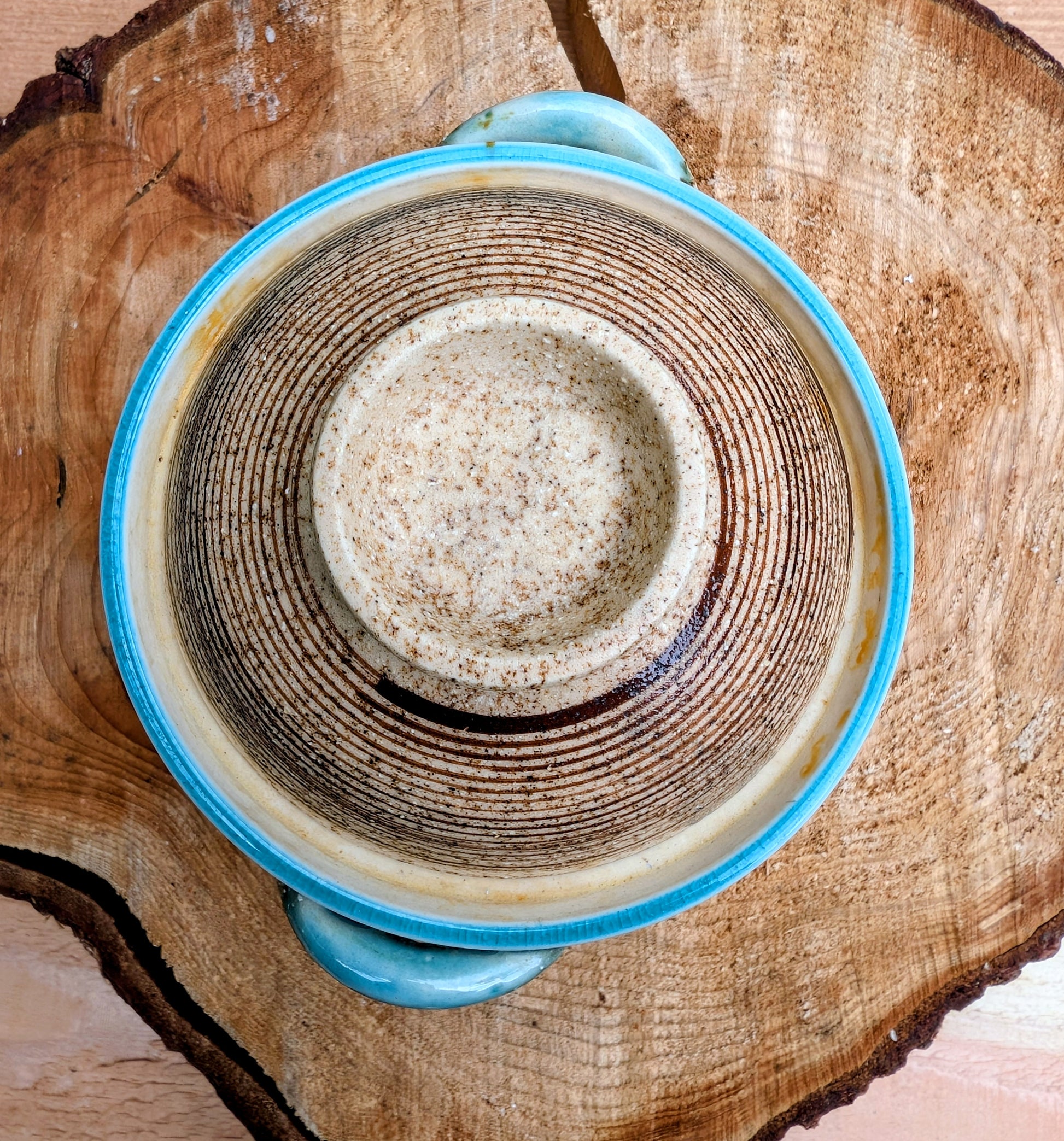 A beautifully handcrafted studio pottery bowl featuring a warm speckled stoneware exterior, vibrant turquoise glazed interior, and matching ribbed lid. Its compact size and organic design make it perfect for serving small dishes or displaying as a timeless piece of artisan pottery.
