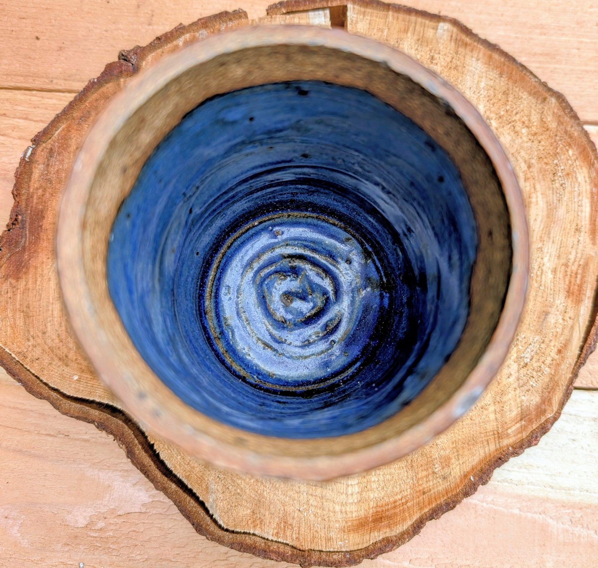 Hand-thrown and artist signed, this versatile stoneware vessel features a rich variegated cobalt blue glaze with an exposed stoneware rim that highlights its handcrafted character. Beautiful as a vase, utensil crock, brush holder, or decorative accent, it brings timeless studio craftsmanship to any home.