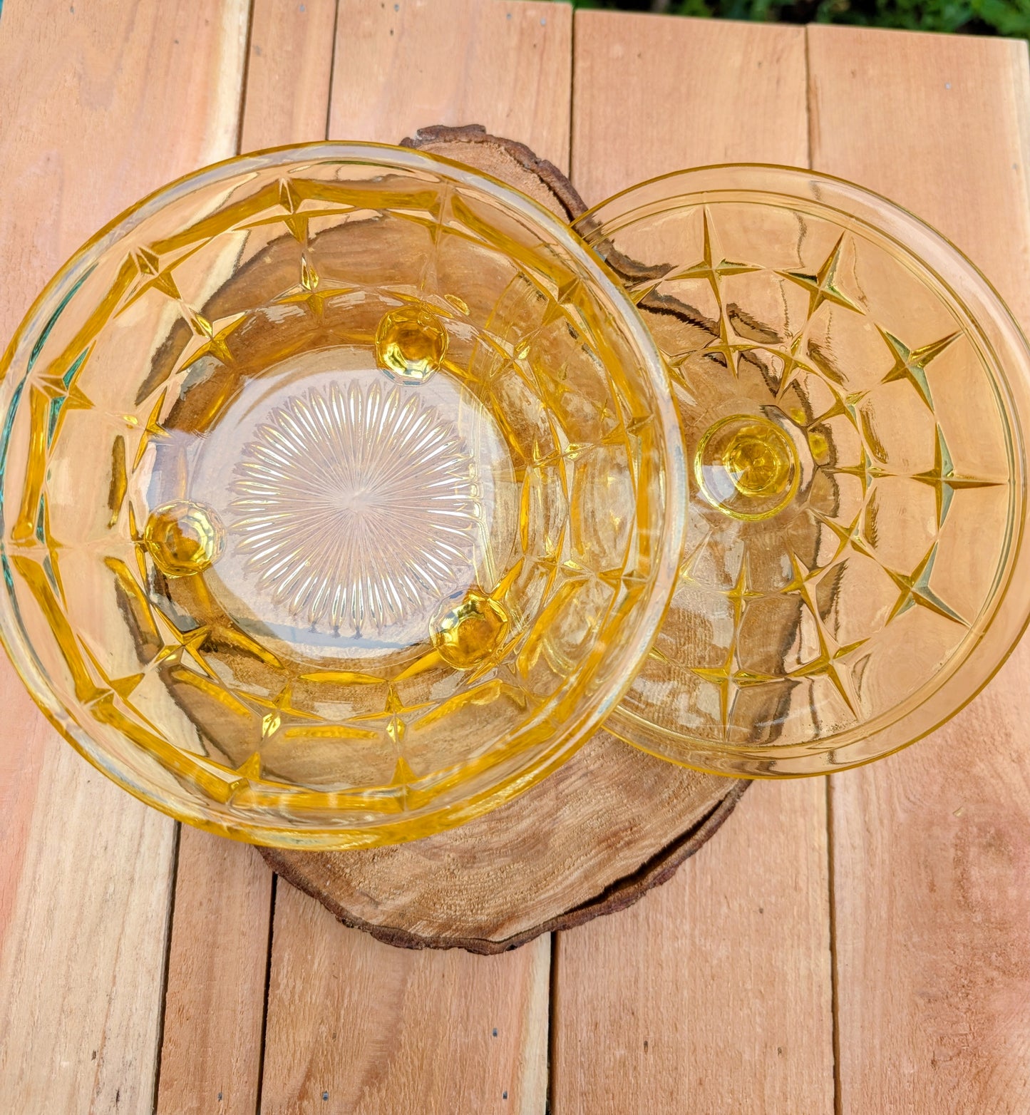 Bring warm vintage charm to your home with this beautiful Tiara Exclusives Constellation covered candy dish in the sought-after Yellow Mist color. Produced by Indiana Glass during the 1970s, its geometric star pattern and golden glow make it a timeless piece for entertaining or display.