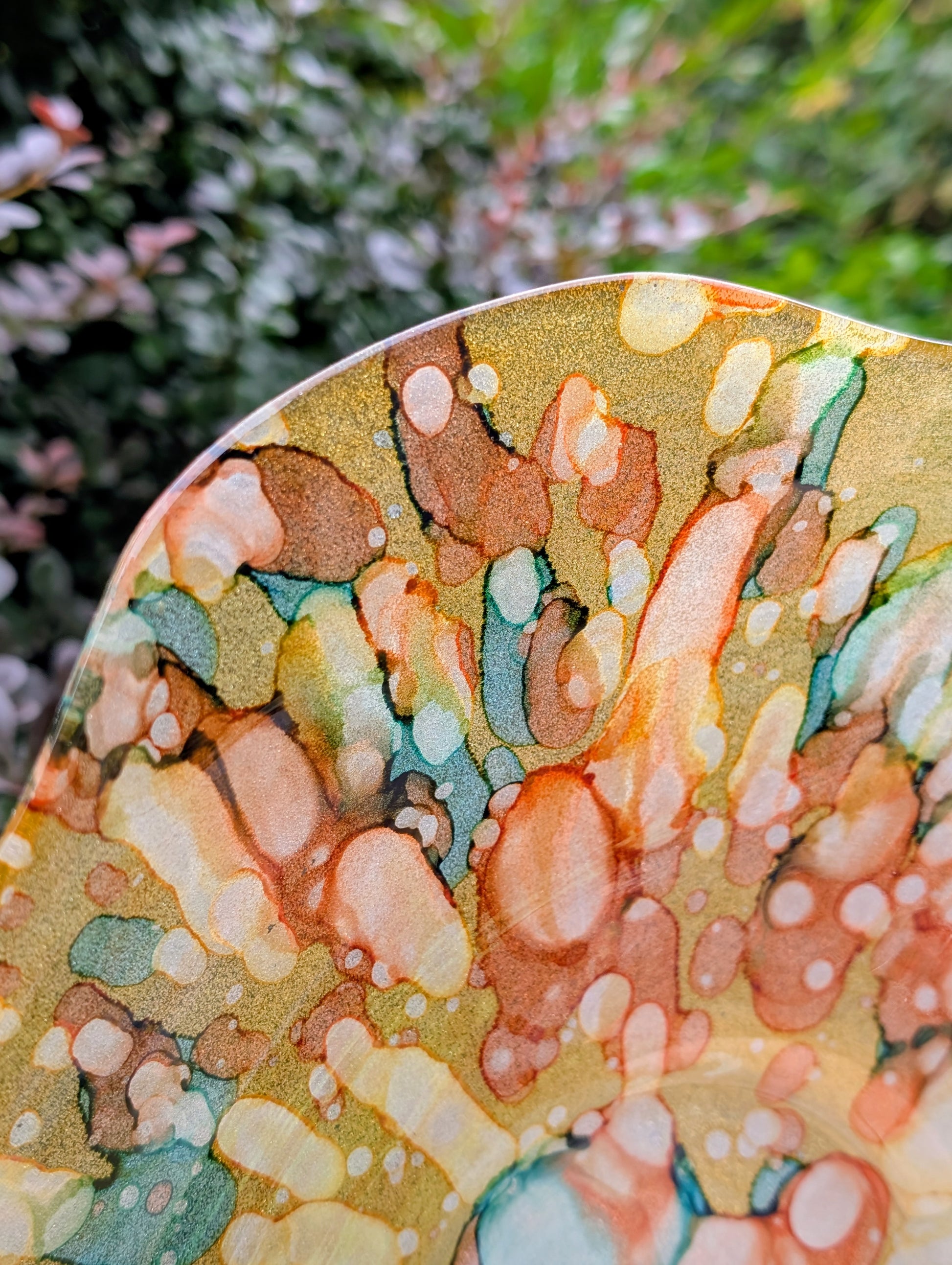Bring color and light to your home or garden with this contemporary scalloped art glass bowl. Featuring warm golden tones accented by olive green, amber, turquoise, and shimmering metallic highlights, it serves beautifully as a centerpiece, decorative bowl, or tabletop bird bath.