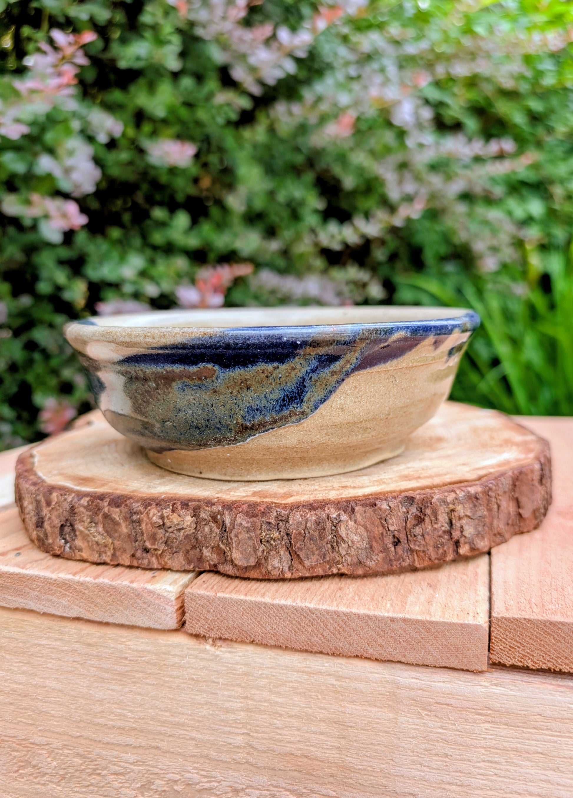 Bring handcrafted warmth to your table with this beautifully wheel-thrown studio pottery bowl, attributed to Gladstone Wear. Featuring flowing cobalt blue, charcoal, and earthy brown glazes over a natural buff stoneware body, it offers timeless artisan appeal for serving or display.
