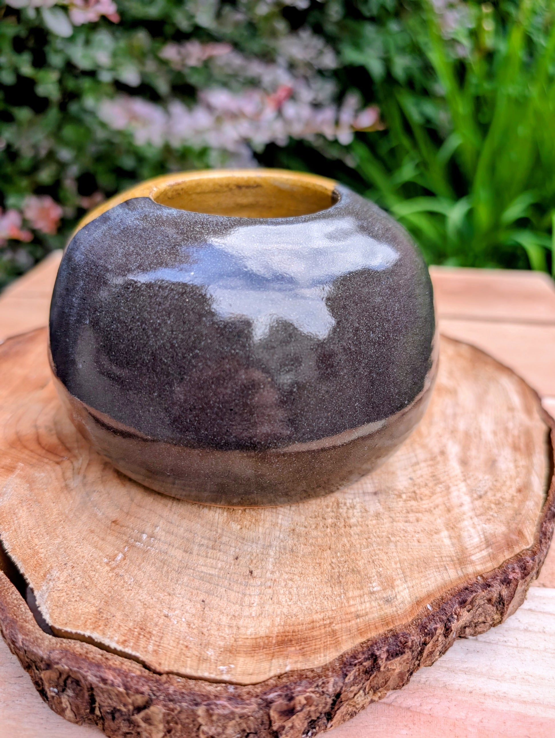 A beautifully hand-thrown studio pottery bud vase dated 1988, featuring a striking half-black, half-mustard glaze accented with expressive iron oxide speckling. Its sculptural form and organic craftsmanship make it equally at home as a minimalist floral vessel or standalone work of ceramic art.