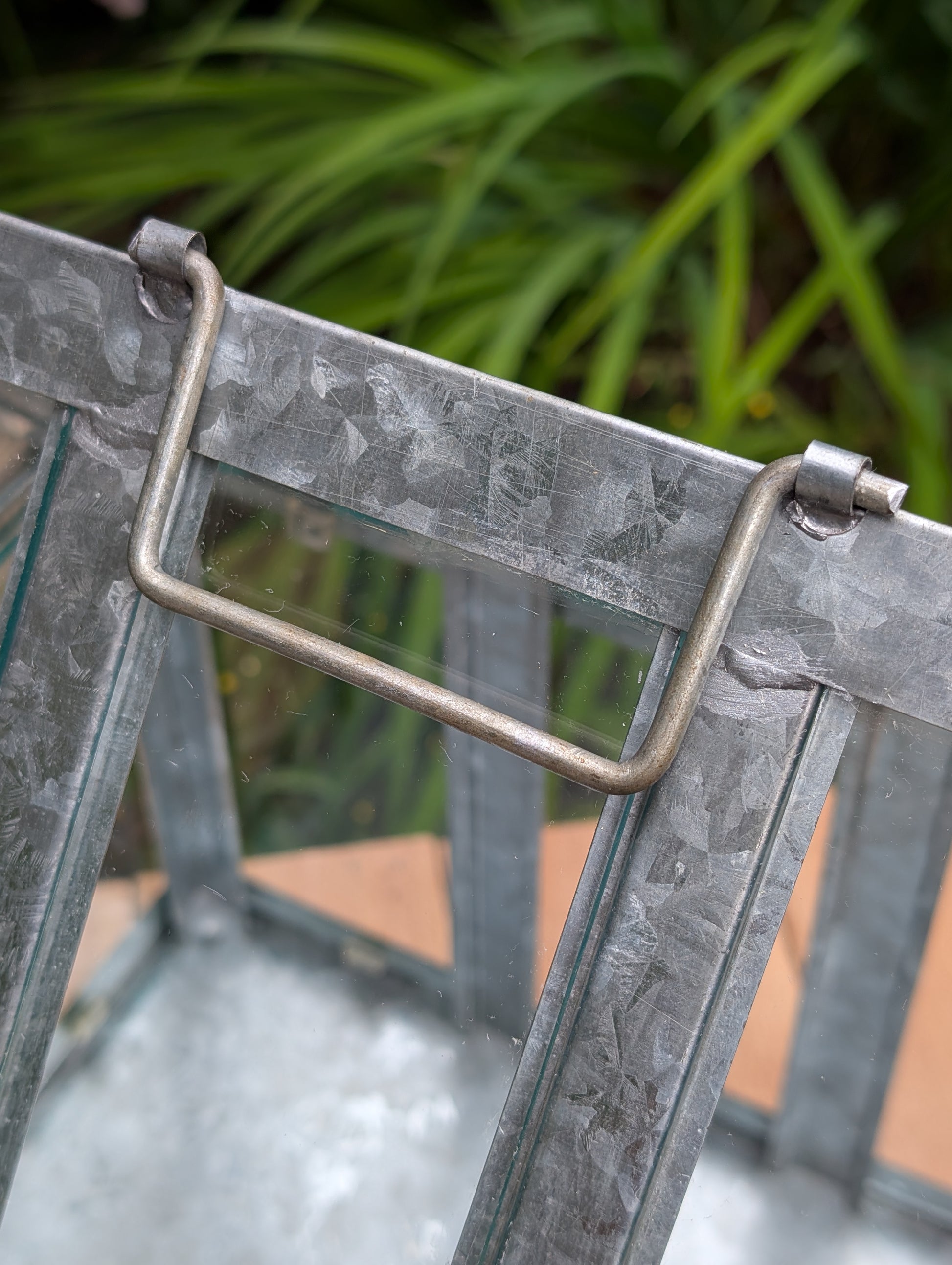 Bring the charm of a Victorian conservatory indoors with this decorative galvanized metal and glass tabletop greenhouse. Perfect for displaying succulents, moss gardens, candles, seasonal décor, or treasured collectibles, it adds timeless botanical style to any room.