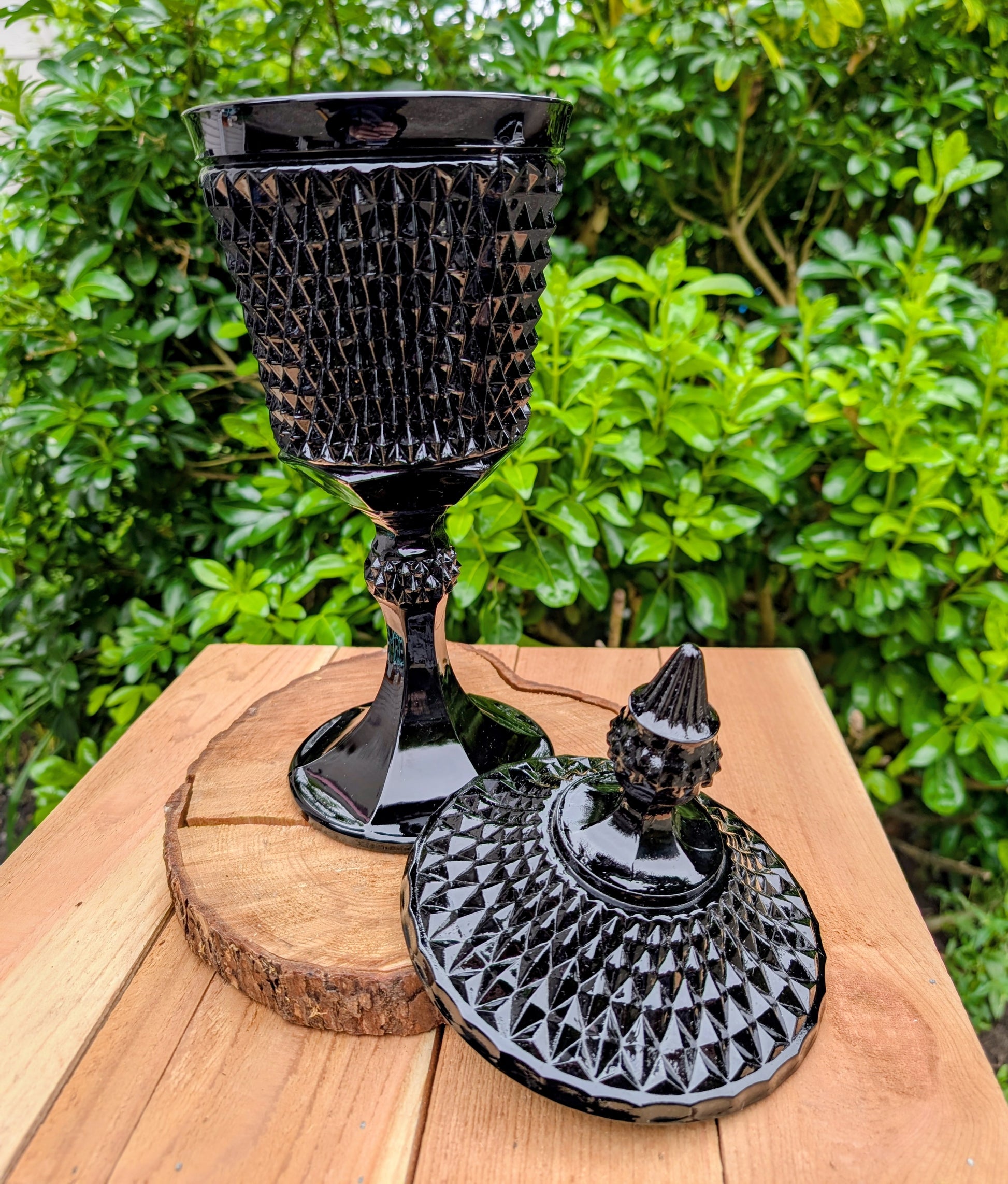Make a dramatic statement with this vintage Tiara Exclusives Diamond Point covered pedestal compote in rich Cameo Black glass. Standing an impressive 16 inches tall, this elegant pressed glass piece is perfect for displaying wrapped candies, seasonal décor, ornaments, or treasured collectibles throughout the year.