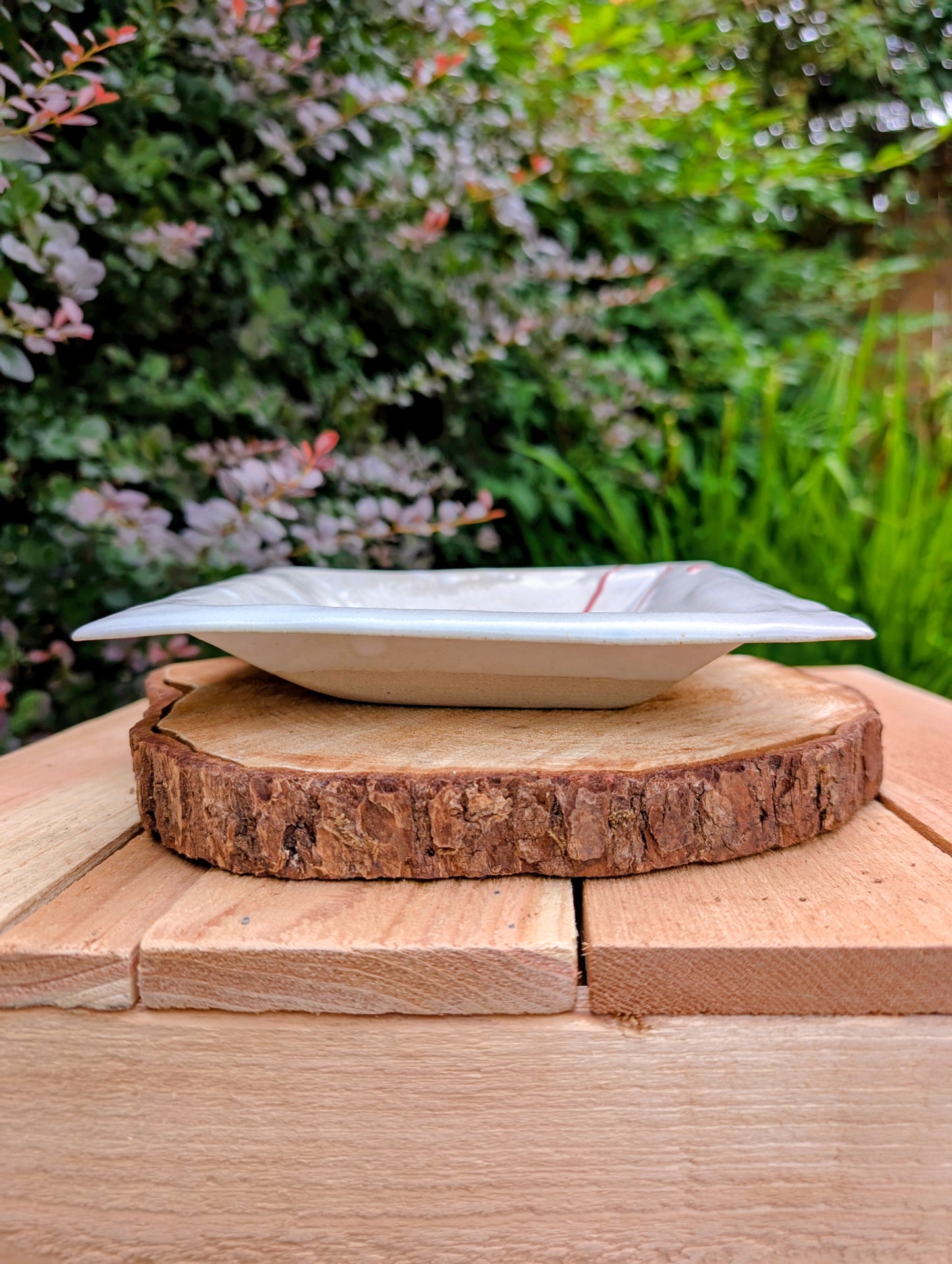 Bring handcrafted artistry into your home with this unsigned studio pottery catchall dish featuring a sculptural folded-corner design and expressive red slip decoration. Beautiful as both functional pottery and contemporary décor, it offers timeless Pacific Northwest style with organic modern appeal.