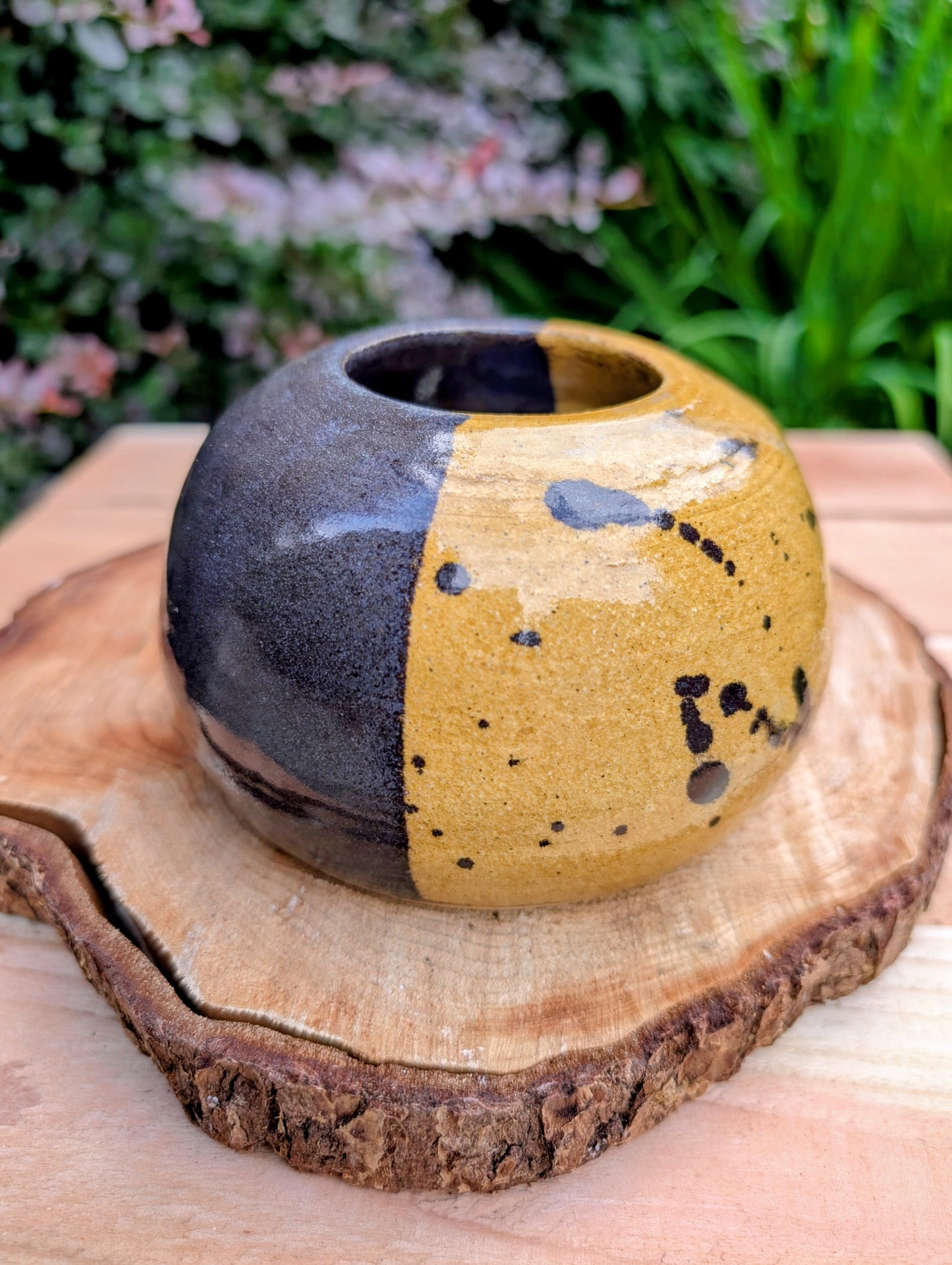 A beautifully hand-thrown studio pottery bud vase dated 1988, featuring a striking half-black, half-mustard glaze accented with expressive iron oxide speckling. Its sculptural form and organic craftsmanship make it equally at home as a minimalist floral vessel or standalone work of ceramic art.