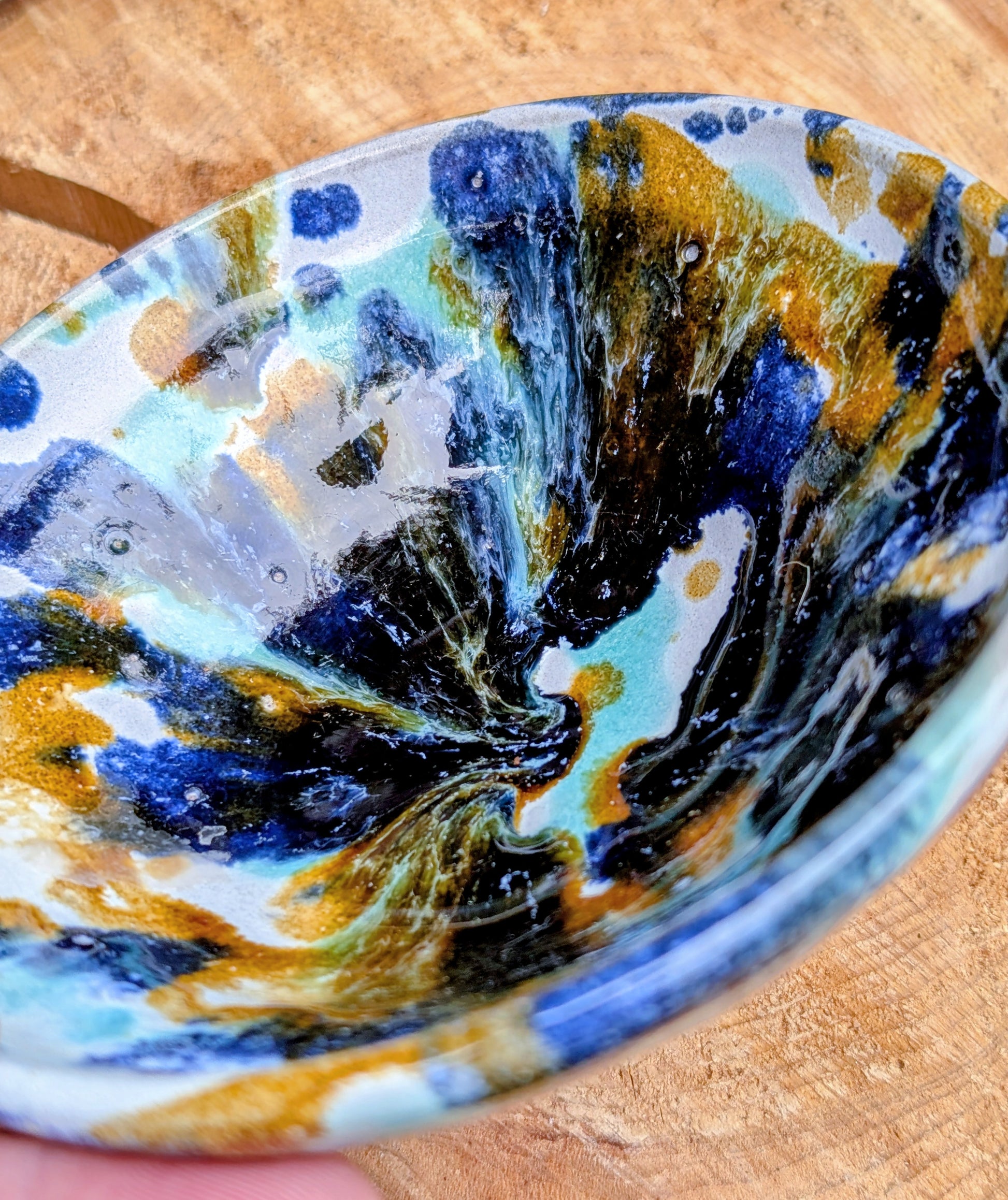 Bring handcrafted artistry to your table with this matching pair of signed studio pottery bowls. Finished with richly layered reactive glazes in cobalt blue, teal, amber, and ivory, these versatile artisan bowls are equally beautiful for entertaining or everyday display.
