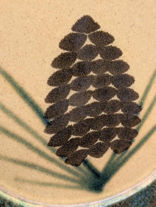 Bring the warmth of the forest to your table with this handcrafted Monroe Salt Works Pine Cone dinner plate. Featuring a classic salt-glazed finish and timeless woodland motif, this beautifully made stoneware piece blends everyday function with rustic New England craftsmanship.