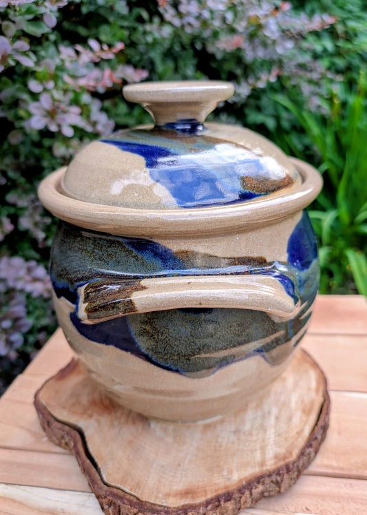 A beautifully handcrafted studio pottery tureen featuring a fitted lid, integrated handles, and a flowing cobalt blue glaze over warm oatmeal stoneware. Both functional and decorative, this artisan serving piece brings timeless craftsmanship and organic beauty to the table