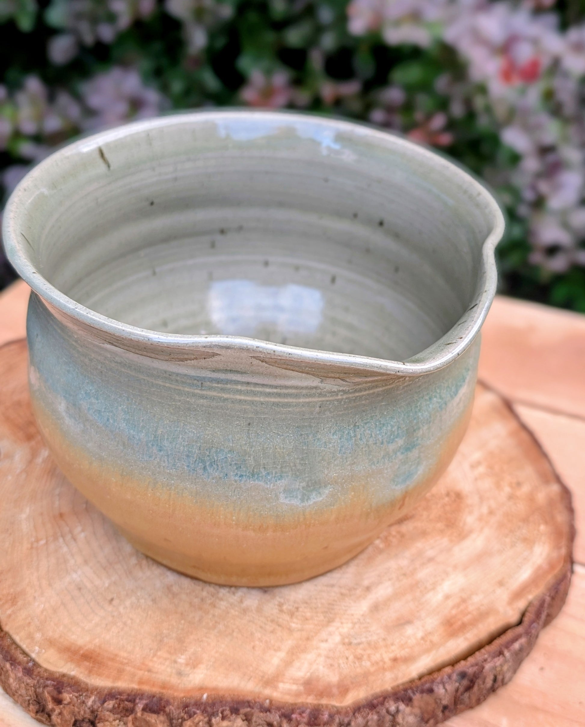 A beautifully hand-thrown studio pottery pouring bowl featuring a soft blue-green celadon glaze over warm buff stoneware. Equally suited for serving, light kitchen use, or display, this artisan-made piece celebrates the beauty of handcrafted ceramics and timeless functional design.