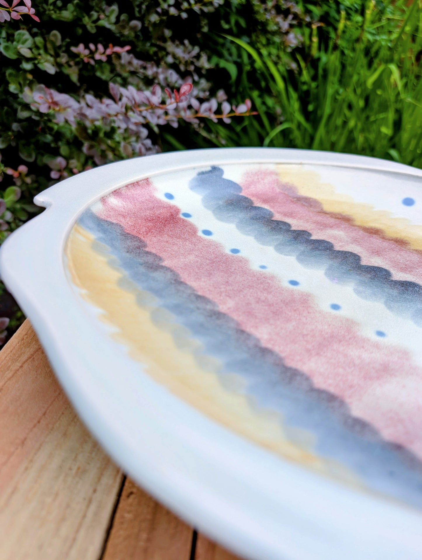 A beautifully handcrafted 14-inch studio pottery platter featuring layered abstract decoration in soft blue-gray, dusty pink, cream, and cobalt accents. Equally stunning as a serving piece or decorative display charger, this artisan-made platter brings timeless craftsmanship to modern living.