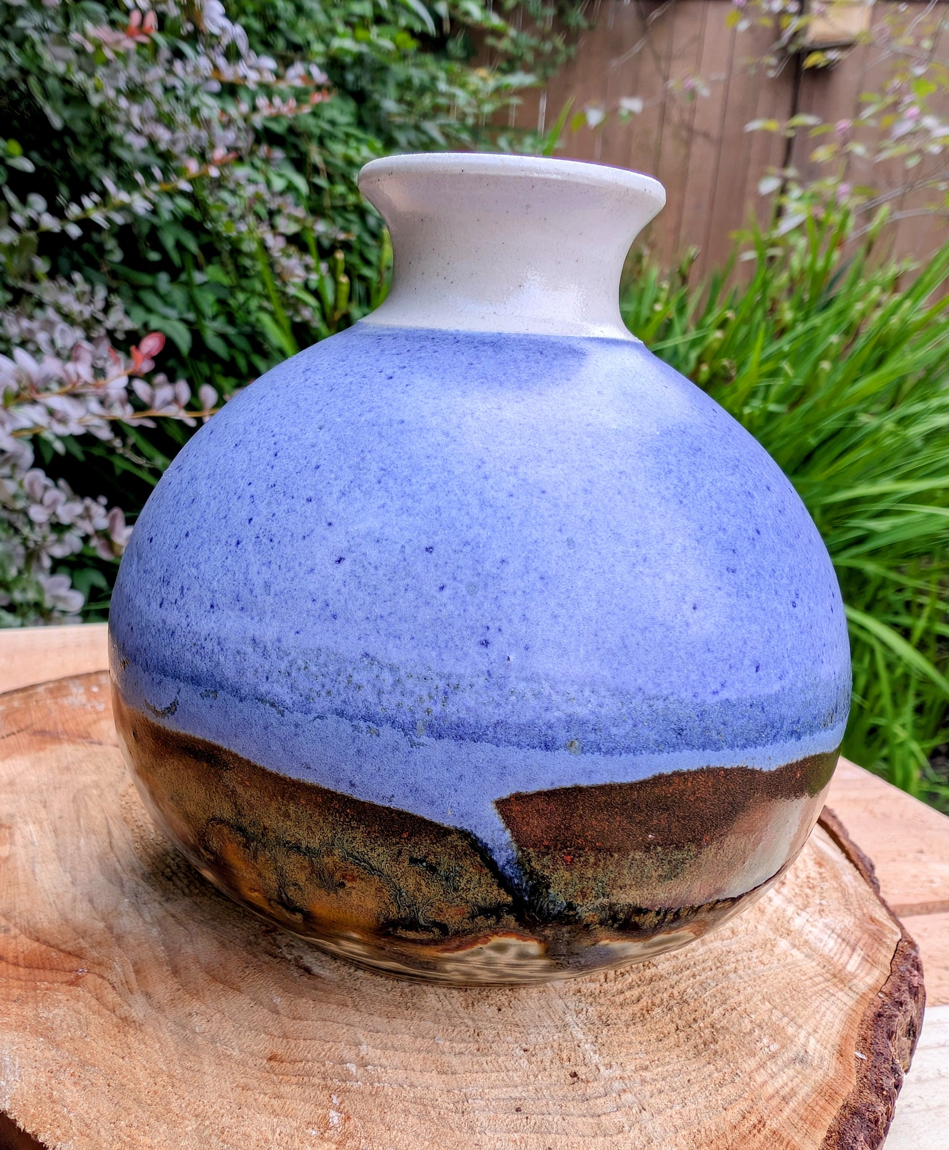 A beautifully signed studio pottery bud vase featuring a softly rounded bubble form and layered landscape-inspired glazes. Its organic silhouette and calming palette make it an elegant accent for modern, minimalist, and nature-inspired interiors.