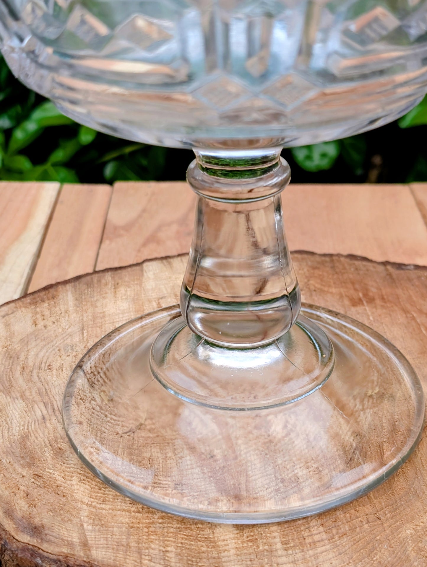 An elegant early 20th-century pressed glass covered compote featuring bold geometric Art Deco styling and a striking pedestal silhouette. Although the pedestal has visible stress cracks, the original lid, impressive scale, and architectural design make it a beautiful decorative display piece.
