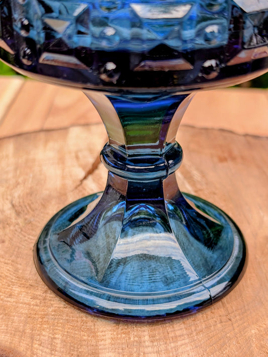 A striking vintage Fostoria Windsor Crown covered chalice in vibrant Royal Blue glass, produced during the early 1960s. With its sculptural pedestal, jewel-like crown rim, and original domed lid, this elegant candy dish is equally at home as a display centerpiece or functional serving piece.