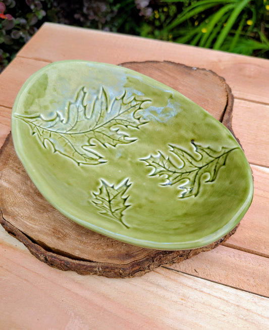 Celebrate the beauty of the forest with this handcrafted embossed oak leaf ceramic dish. Featuring a rich olive-green glaze and an organic form, it's equally at home serving small bites, holding jewelry, or adding a touch of Pacific Northwest charm to your décor.