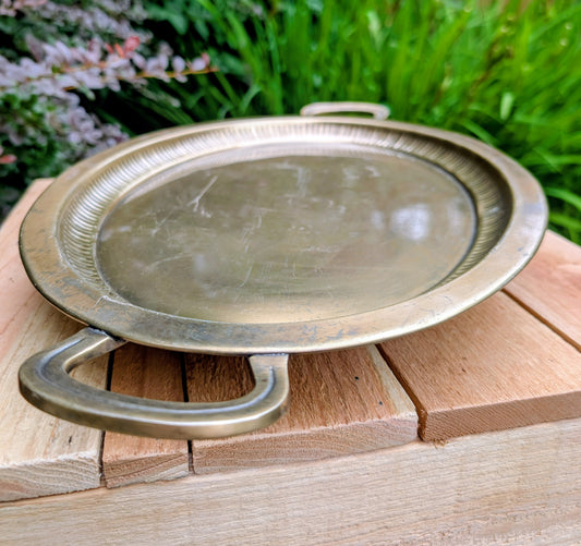 Bring timeless warmth to your home or garden with this vintage brass-tone handled tray, thoughtfully sourced and curated by Cedar & Song Studio. Originally created as decorative home décor, it now offers beautiful possibilities as a display tray or repurposed bird feeding platter for nature-inspired outdoor spaces.