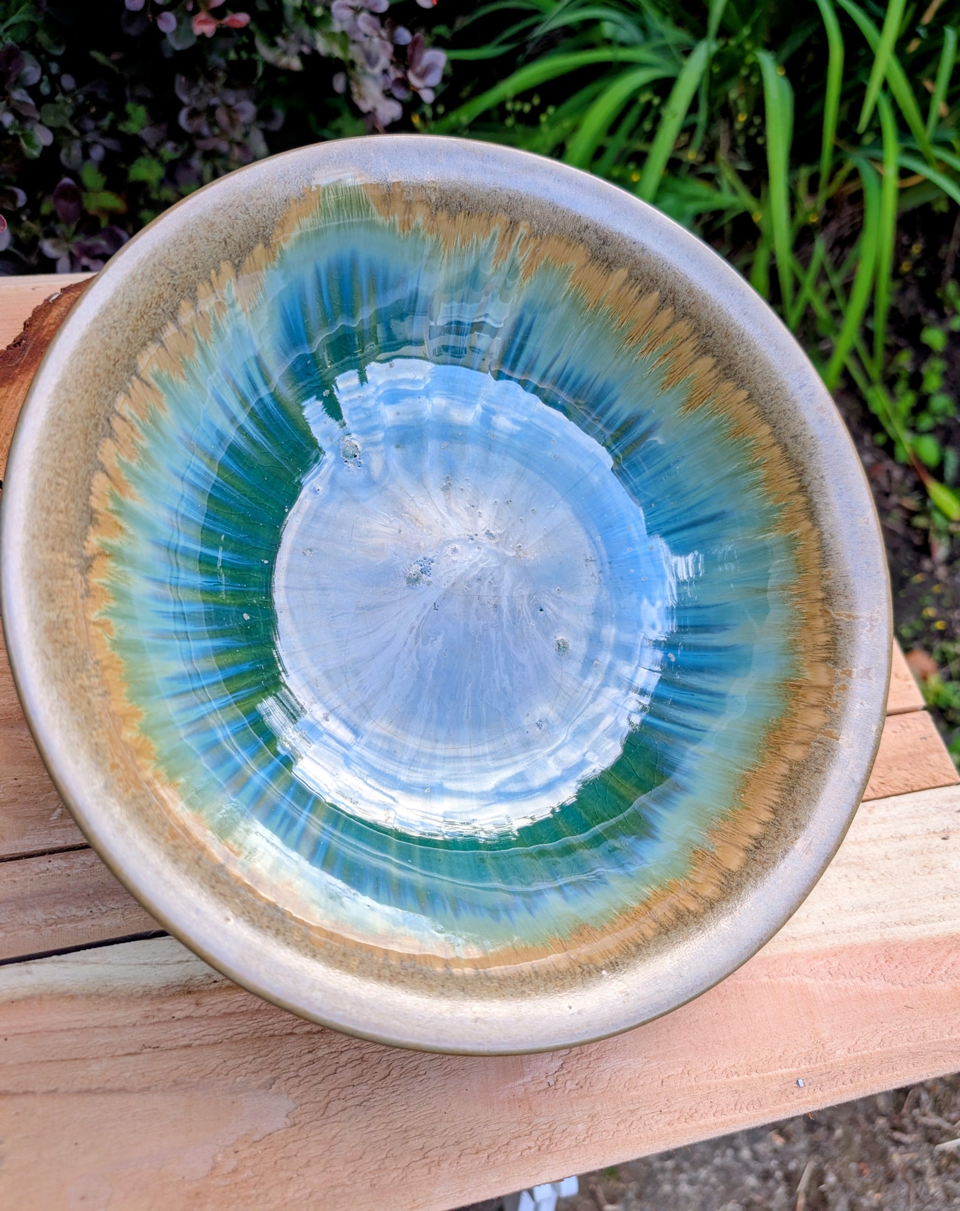 A beautifully handcrafted studio pottery bowl featuring layered blue, celadon, and copper reactive glazes with striking crystalline patterning. This artisan stoneware piece makes an eye-catching centerpiece or decorative accent inspired by the colors of Pacific Northwest waters.