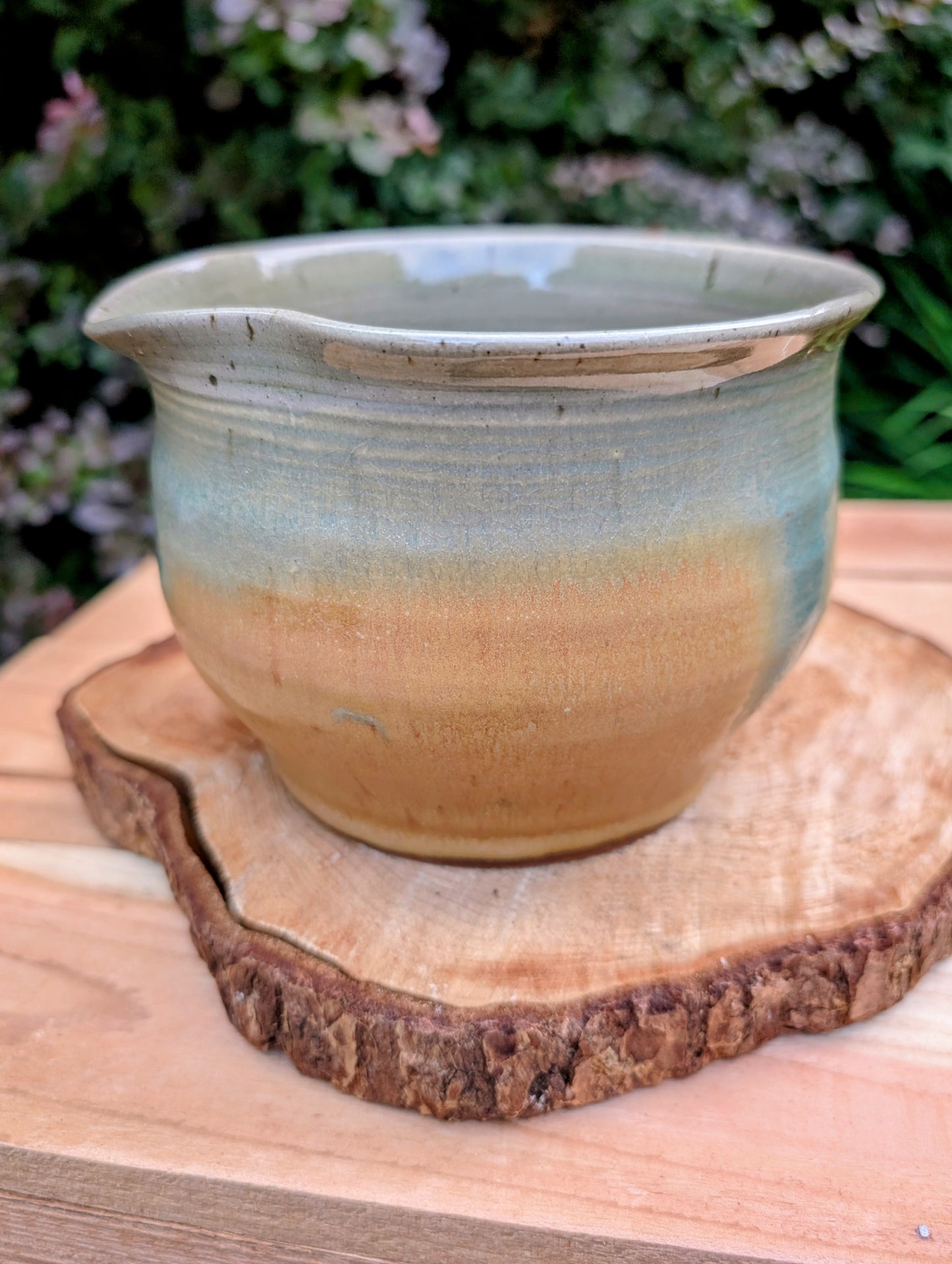 A beautifully hand-thrown studio pottery pouring bowl featuring a soft blue-green celadon glaze over warm buff stoneware. Equally suited for serving, light kitchen use, or display, this artisan-made piece celebrates the beauty of handcrafted ceramics and timeless functional design.