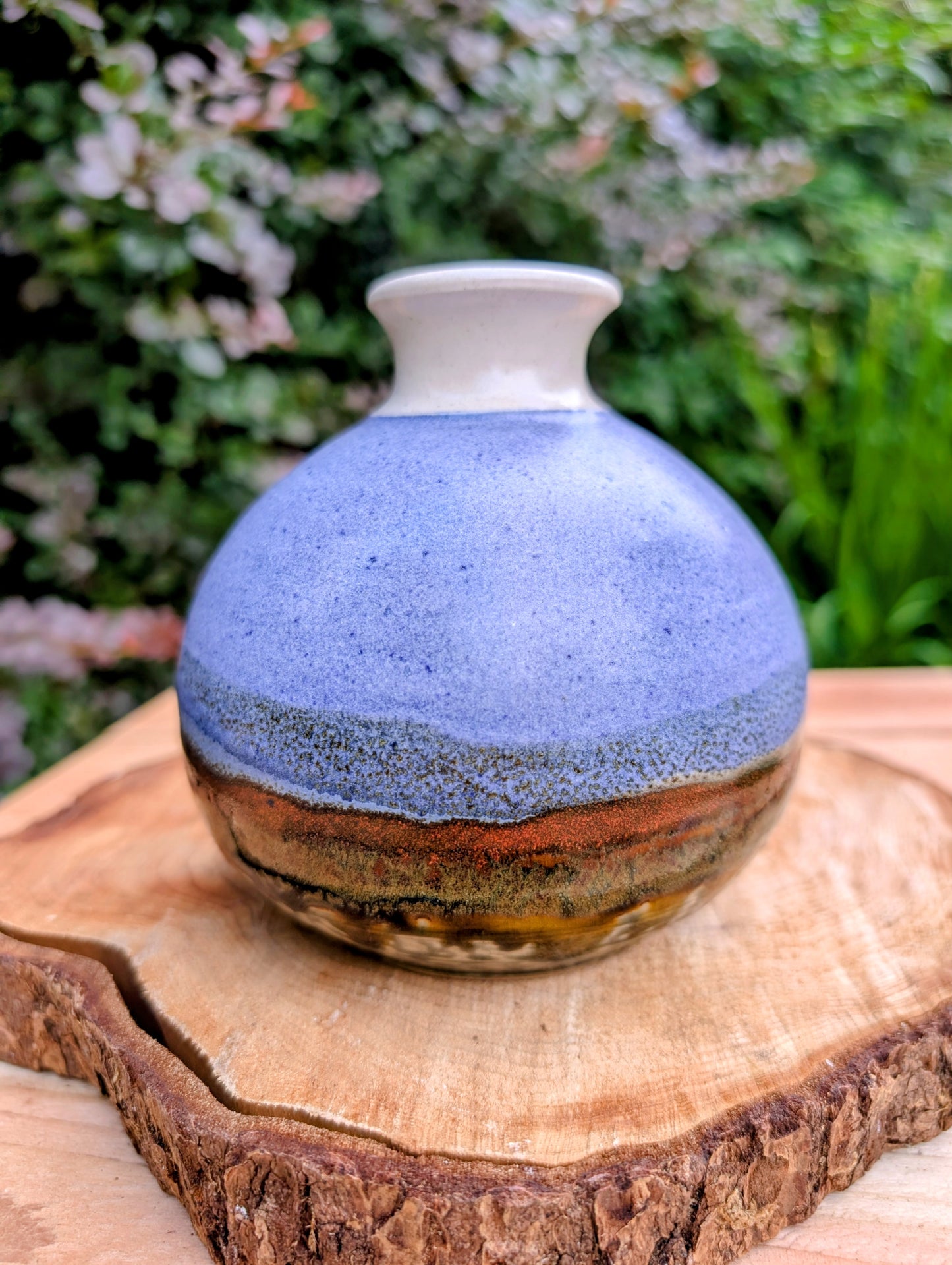 A beautifully signed studio pottery bud vase featuring a softly rounded bubble form and layered landscape-inspired glazes. Its organic silhouette and calming palette make it an elegant accent for modern, minimalist, and nature-inspired interiors.