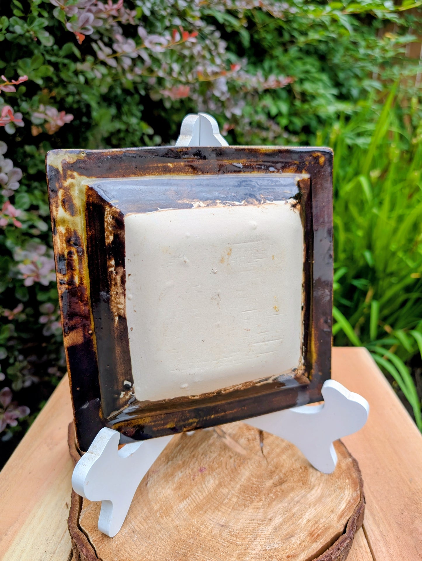 Bring handcrafted artistry into your home with this one-of-a-kind square studio pottery dish. Its rich chocolate brown glaze is accented by constellation-like blue, green, and cream crystalline details, making it equally beautiful as a decorative catchall, appetizer dish, or display piece.