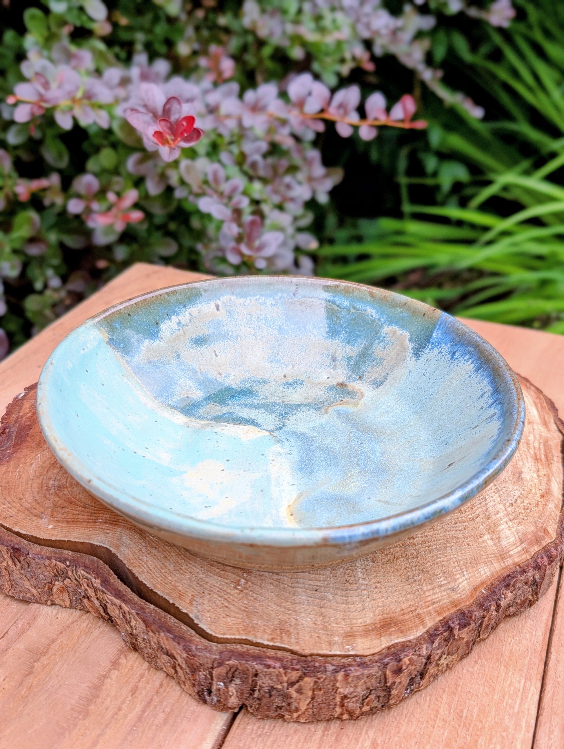 Bring the calming colors of the Pacific Northwest into your home with this handcrafted studio pottery bowl. Featuring layered blue, aqua, cream, and olive reactive glazes, this artisan stoneware piece is equally beautiful as a serving bowl or decorative display.