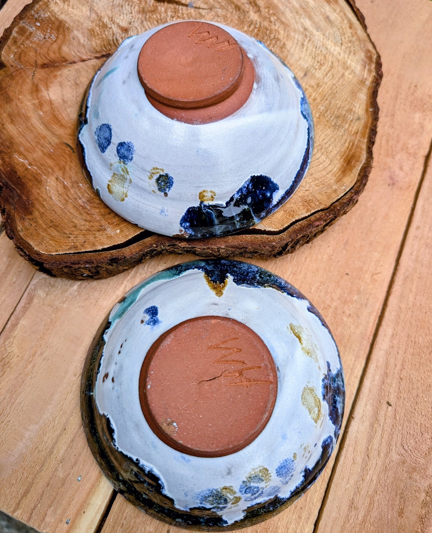 Bring handcrafted artistry to your table with this matching pair of signed studio pottery bowls. Finished with richly layered reactive glazes in cobalt blue, teal, amber, and ivory, these versatile artisan bowls are equally beautiful for entertaining or everyday display.