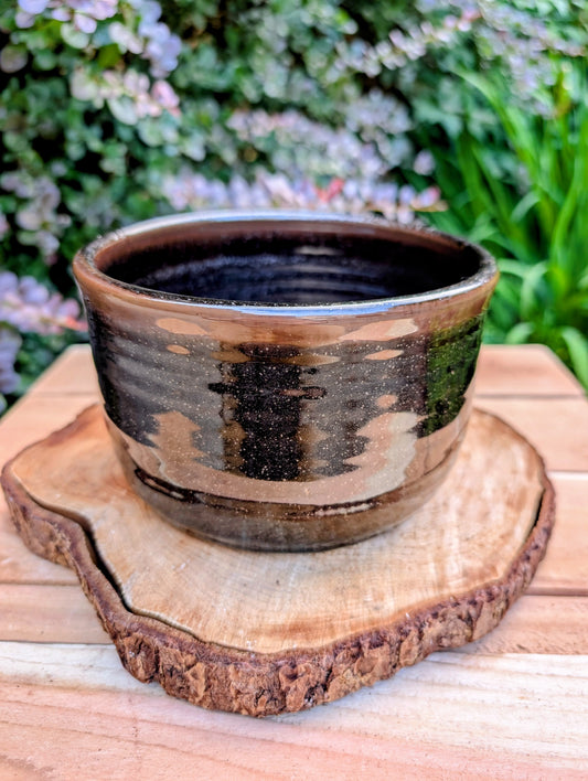 Bring the warmth of Pacific Northwest craftsmanship to your home with this authentic Bruning Pottery stoneware bowl from the studio's Seattle era. Featuring a rich iron-speckled glaze and wheel-thrown construction, it's equally beautiful as a serving bowl, planter cachepot, or decorative display piece.