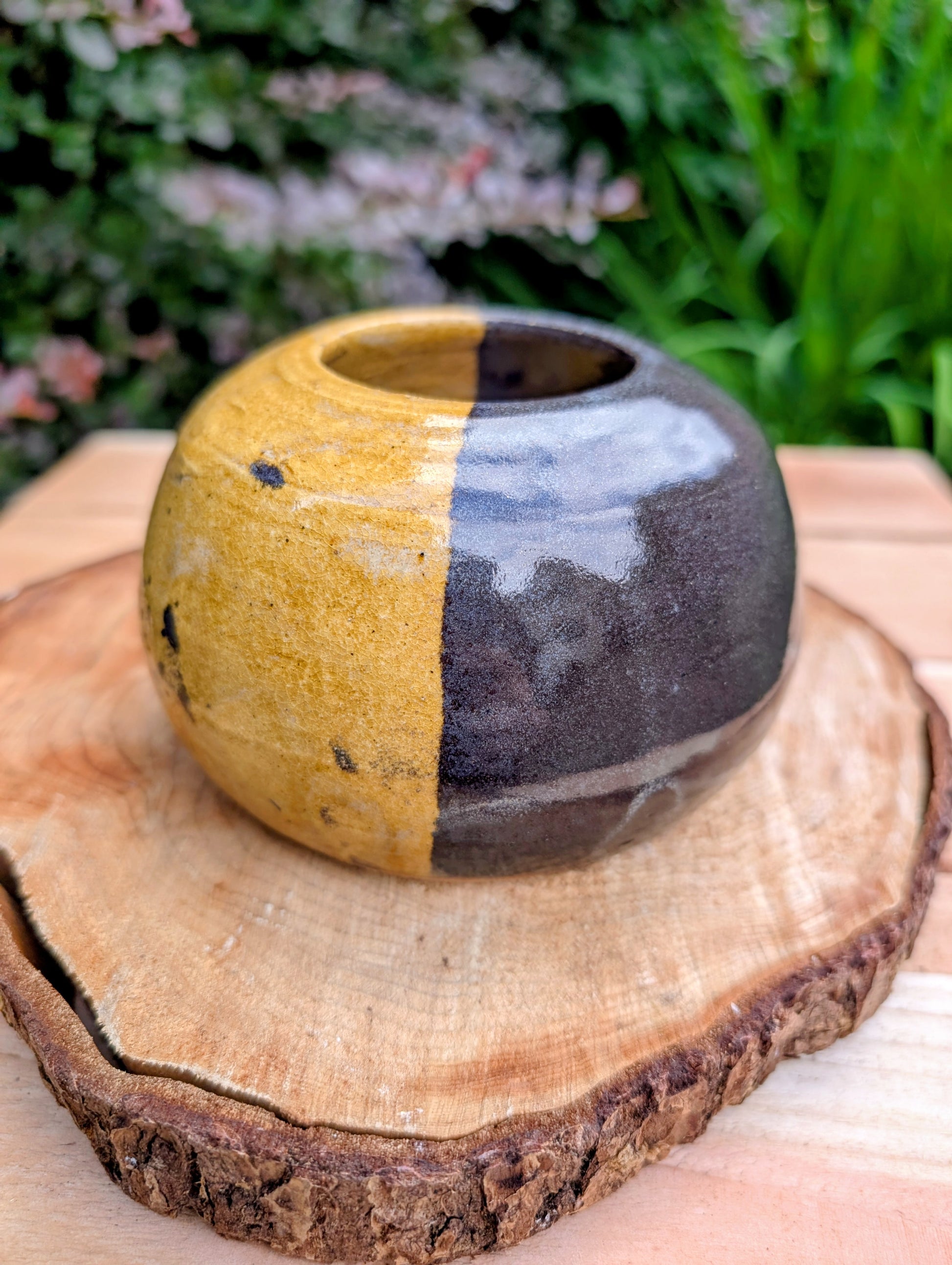 A beautifully hand-thrown studio pottery bud vase dated 1988, featuring a striking half-black, half-mustard glaze accented with expressive iron oxide speckling. Its sculptural form and organic craftsmanship make it equally at home as a minimalist floral vessel or standalone work of ceramic art.