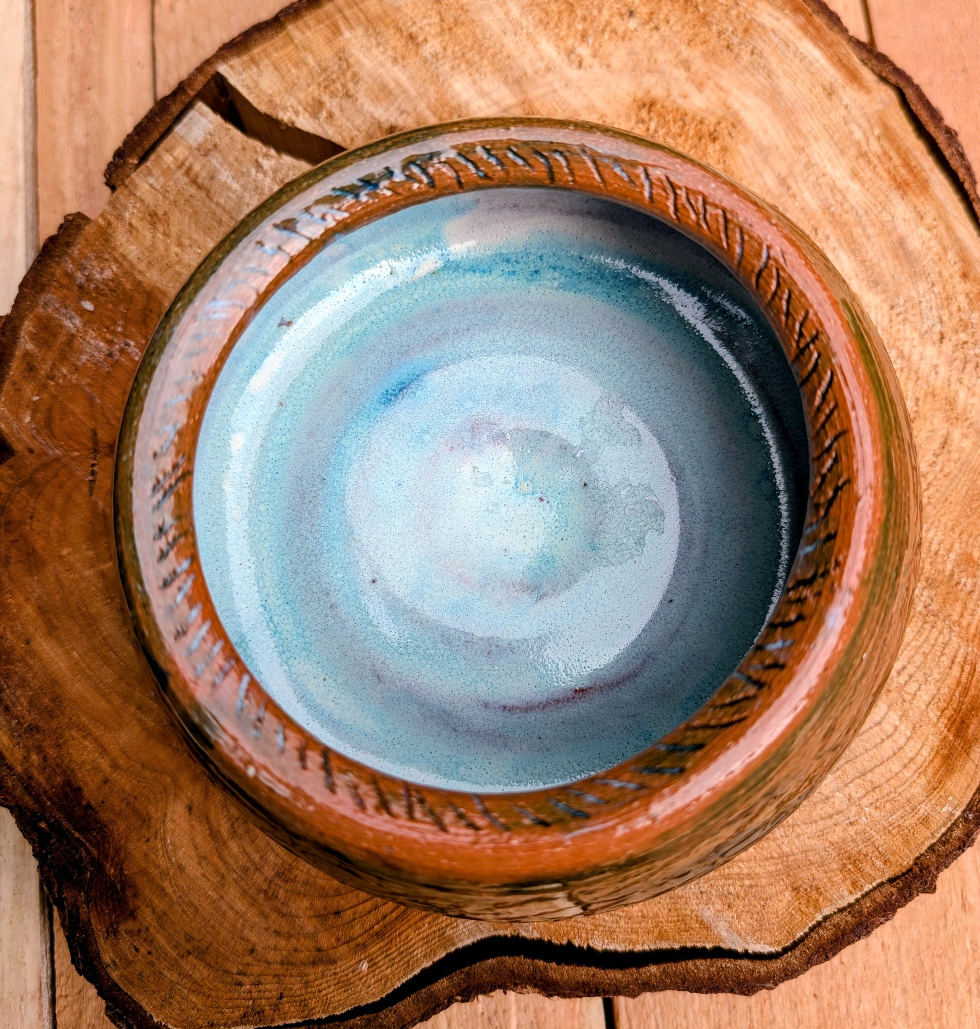 Handcrafted with richly carved texture and a soft blue reactive glaze, this signed studio pottery bowl brings warmth and character to any home. Ideal as a serving bowl, decorative accent, or functional piece of everyday artisan pottery.