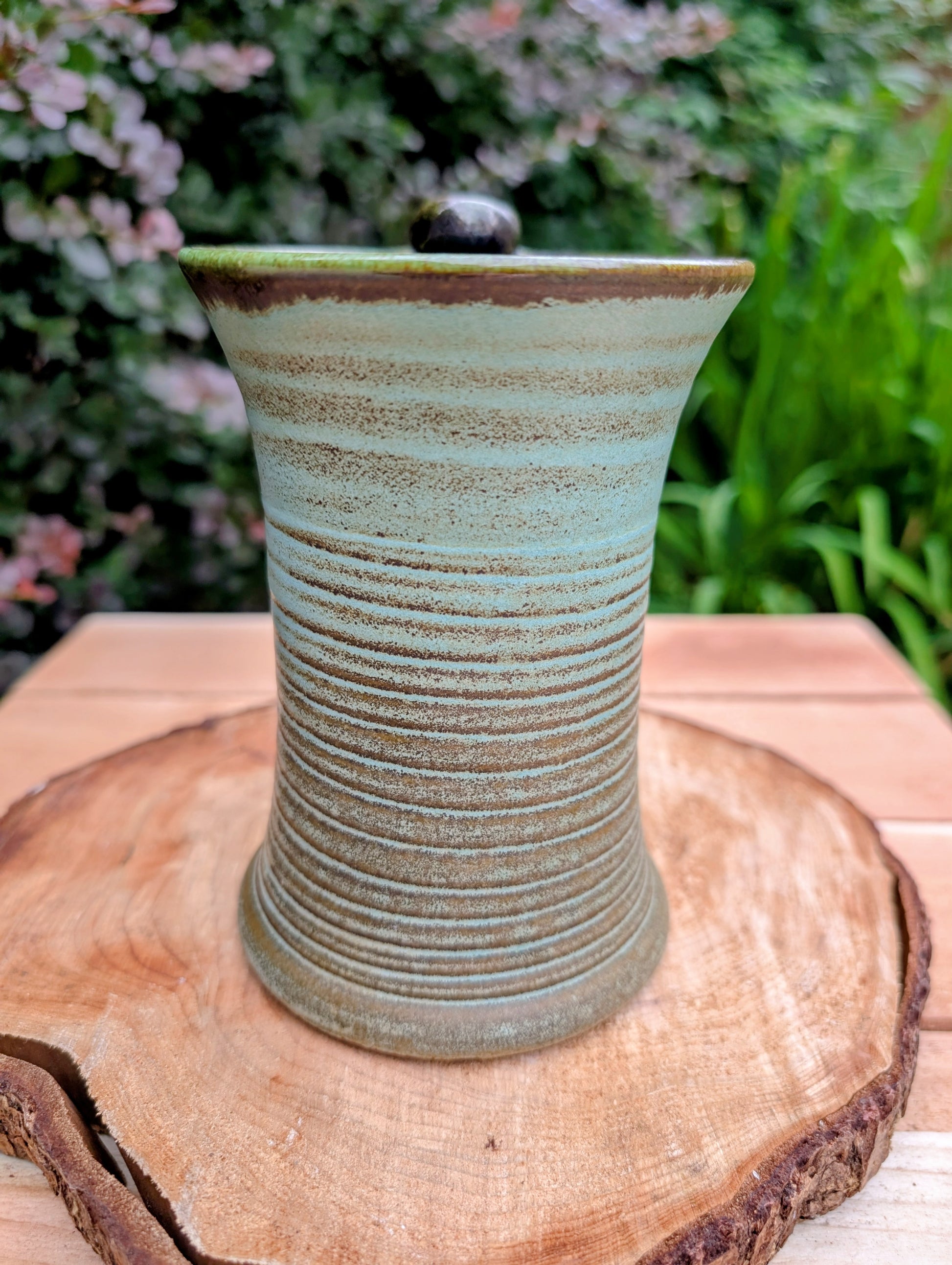 A beautifully handcrafted studio pottery tankard-style mug, wheel-thrown in Hot Springs, Arkansas and dated 2007. Its flowing turquoise, olive, and bronze glaze, generous size, and comfortable thumb-rest handle make it both a functional everyday piece and a collectible example of American studio pottery.