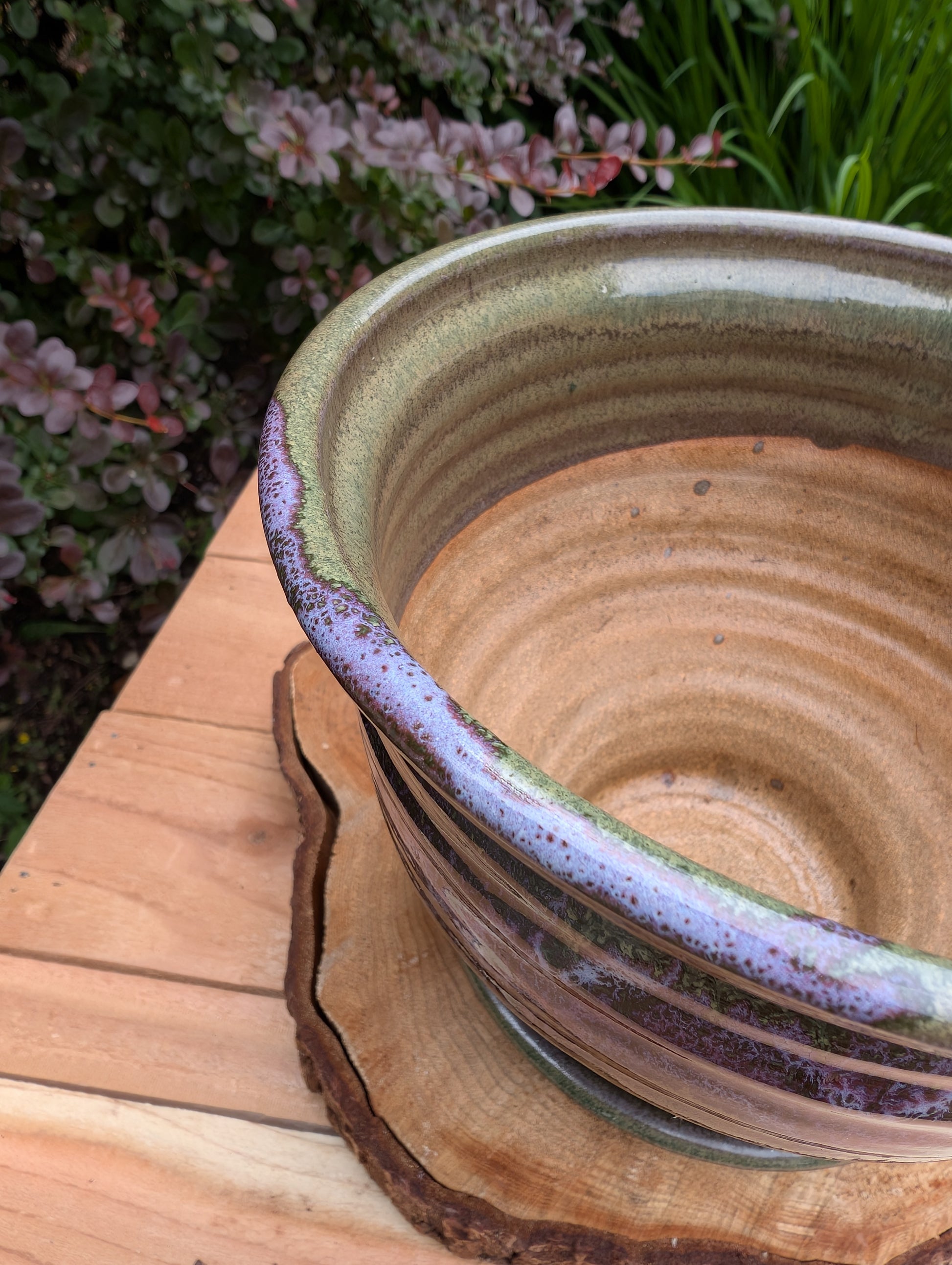 Handcrafted in Snohomish, Washington, this authentic Bruning Pottery stoneware planter showcases flowing moss green, olive, brown, and plum glazes inspired by the Pacific Northwest landscape. Complete with an integrated saucer, it's a beautiful and functional piece for houseplants, herbs, or succulent collections.